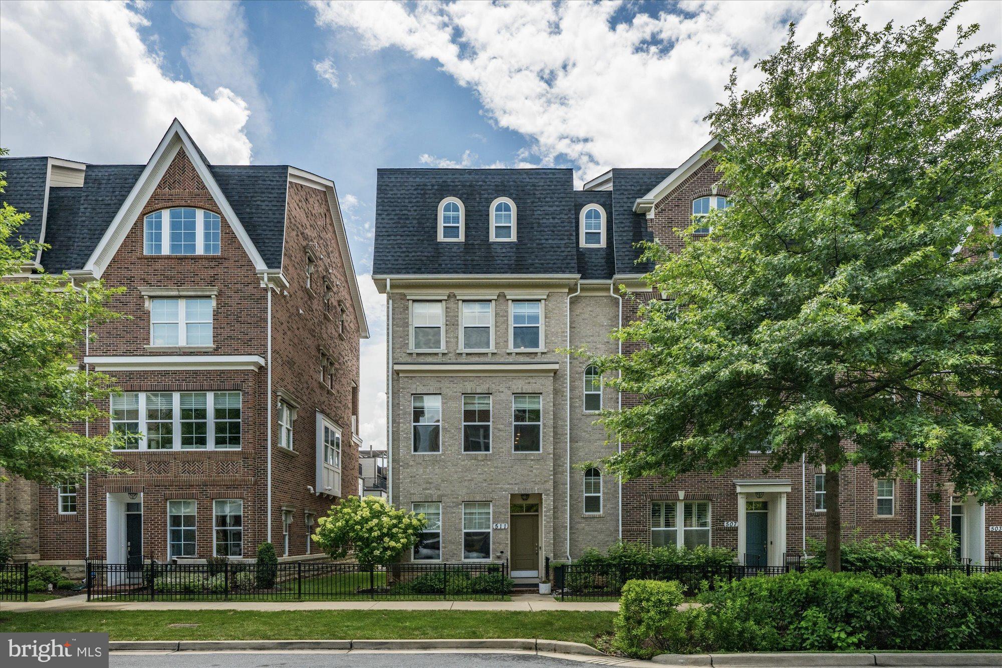 Welcome to 511 Crown Park Avenue, an exceptional Midori model end townhome built by KB Homes, ideally situated in the sought-after Crown Farm community of Gaithersburg, Maryland. Boasting nearly 3,400 square feet of meticulously maintained living space, this stylish residence features three spacious bedrooms, four and a half bathrooms, two private balconies, and a host of premium upgrades throughout.
Step inside the front door and be greeted by gleaming hardwood floors, elevated ceilings, and an abundance of natural light streaming through oversized windows that grace every level of the home. The entry level offers a versatile space—perfect for a bonus living area, home office, or easily enclosed guest suite. A full bathroom with a sleek walk-in shower is thoughtfully positioned for convenience. Ample storage abounds with a sizable hall closet, and a bonus closet designed with elevator-ready infrastructure, complete with pre-installed shafts and supports for seamless future installation. The spacious two-car garage offers elevated ceiling height and built-in overhead storage racks.
Continue to the main level, where the open-concept floorplan delivers the seamless flow todays buyers covet. The gourmet kitchen is an entertainer’s dream, featuring a distinctive oversized island with bar seating and stylish pendant lighting. Outfitted with stainless steel appliances, abundant soft-close cabinetry, coffee bar area and a generous walk-in pantry with custom build out, this kitchen offers both beauty and functionality—perfect for hosting and everyday living alike. An open deck off the kitchen features a retractable screen door and a built-in gas line for a grill, making it ideal for outdoor entertaining.The dining area easily accommodates larger gatherings, while the sun-bathed living space is wrapped in windows and anchored by a custom feature wall with a gas fireplace and mounted TV. A redesigned powder room, highlighting a marble under mount sink, and two additional closets round out this main level.
Ascend to the upper level, where a bright and inviting lounge area awaits at the top of the stairs—complete with a wet bar and beverage refrigerator. This level hosts two generously sized bedrooms, each with spacious custom built-out walk-in closets. One bedroom features a handsome paneled accent wall and a private en-suite bathroom with dual vanities, while the second bedroom—enhanced by modern pendant lighting—shares access to a hall bathroom. A conveniently located laundry room with built-in cabinetry, and roomy hall closet complete this level.
The top-level primary suite is a true private retreat, thoughtfully designed with its own dedicated entrance. This sizable bedroom features a striking accent wall, elegant tray ceiling, built-in wet bar, and access to a private balcony—perfect for enjoying morning coffee or evening sunsets. The spa-inspired bathroom offers a serene escape, complete with an oversized soaking tub, glass-enclosed walk-in shower, expansive dual vanities, and a generous linen closet. Dual custom walk-in closets with built-in shelving provides ample storage to keep you organized.
The true highlight of this home is its unbeatable location. Just steps from Downtown Crown & Rio, you will enjoy a vibrant lifestyle with shops, restaurants, grocery stores, and entertainment all within walking distance. Perfectly positioned in the heart of Gaithersburg, and just minutes from I-270, this home is perfectly connected. With everything this unique home offers in such a desirable neighborhood, it will not be available for long. Do not miss the rare opportunity to make this yours today.