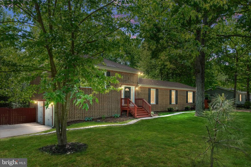 Situated on a generous double lot, this inviting home combines classic charm, unique design, and everyday comfort. With its brick exterior, tasteful finishes,and fresh paint throughout it offers great curb appeal and a warm, welcoming presence that feels like home the moment you arrive.
As you enter through the welcoming custom tiled foyer and into the living space, you’re immediately greeted by hardwood floors and a sunlit living room with large windows that bring the outdoors in. From here, you’ll move seamlessly into the tiled dining room and then into the kitchen, which is truly the heart of the home. Designed with both function and flair, the kitchen features a central island, ample cabinet and pantry space, stainless steel appliances, and a cozy coffee bar area—ideal for both everyday routines and entertaining.
Just off the dining area, a deck with a pergola overlooks the tree-lined backyard, offering a peaceful spot for morning coffee or relaxing evenings. A few steps from the main living area, you'll find a flexible sitting, gaming or office space, two bedrooms—one with its own private bath—a full hall bathroom with a tub and shower combo, and a spacious primary suite. The primary bedroom is filled with natural light from tall windows and includes a walk-in closet and a private en suite with a large soaking tub and separate shower. Wood-finish ceramic tile flooring flows throughout this level, offering both beauty and easy maintenance. The Washer and Dryer are conveniently located on this level.
The attached garage comfortably fits two cars and offers extra storage, plus there’s a bonus conditioned room with windows and a private exit to the backyard—perfect for a workshop, fitness space, or future finished room. Outside, the lot offers room to roam, with open yard space and mature trees providing the perfect backdrop for outdoor living that could include nights around the firepits. With two driveways, there’s plenty of parking for guests, trailers, or extra vehicles.
Located within the gated community of Lake Land’Or, this home includes access to a range of amenities such as a private beach, community dock, clubhouse, and more. You’ll enjoy the peaceful setting and friendly neighborhood feel, all while being just minutes from I-95. Conveniently situated between Washington, D.C., and Richmond—and close to the historic charm of Fredericksburg and the small-town appeal of Bowling Green—this home offers more than just a place to live. Here, you’ll find the best of community living with easy access to everything Northern and Central Virginia have to offer. Cooktop replaced 4/29/25  Roof-2012. Water Heater-24, Oven Panel on order