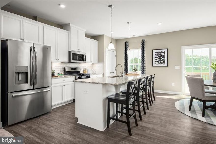 Welcome to the Mendelssohn, where the convenience of townhome living meets the amenities of a single family home. On the main living level, an enormous Country Kitchen with a large island opens onto a bright and airy Living Room, perfect for entertaining and featuring a conveniently placed powder room. Upstairs are two spacious extra bedrooms with ample closet space and a hall bath, and a generous primary Bedroom that features a tray ceiling and a huge walk-in closet. A separate primary Bath features dual vanity and large walk in shower with optional seat. No matter what you choose, you'll still have a convenient 2nd floor laundry with room for side-by-side washer and dryer. Lower level includes large finished Recreation Room. Photos are representative. Lot Premium may apply.