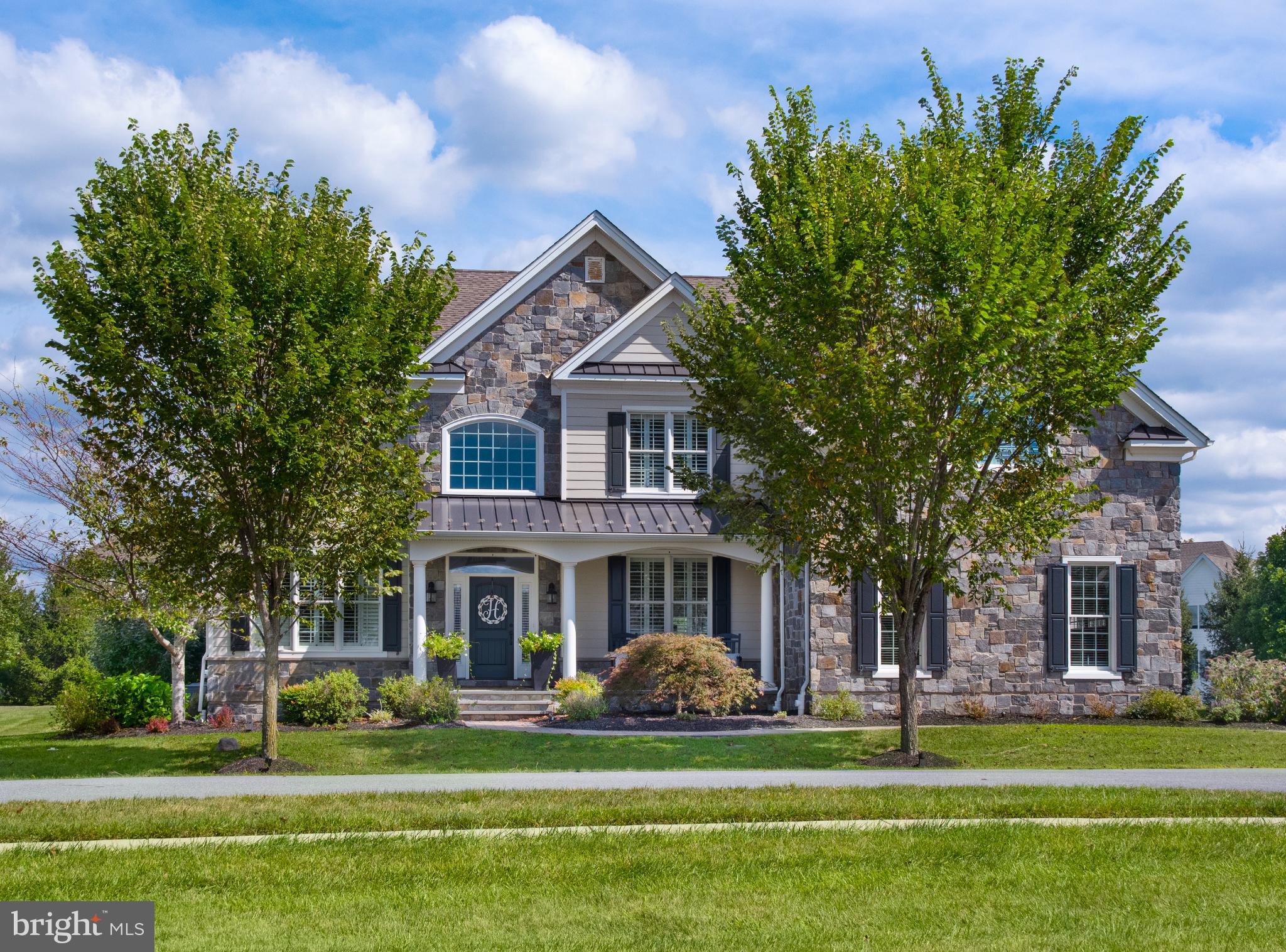Welcome to 307 Green Bank Lane in the sought-after community of Liseter. This expanded Duke model was built with nearly every structural upgrade, offering thoughtful spaces for both everyday living and entertaining.
Step inside to a bright two-story foyer with a sweeping staircase. To the right is the dining room, perfect for holidays and gatherings, while to the left sits a living room that can also serve as a home office or study. At the heart of the home, the two-story family room with fireplace opens into a gourmet kitchen and additional flex spaces. Just off the family room is a sun-filled playroom (ideal as a second office or homework space) and a sunroom that walks out to the deck for easy indoor-outdoor living.
The kitchen is designed for both style and function, anchored by an oversized island large enough for seating, prep, and serving. Outfitted with top-tier appliances, it features a gas range top, double wall oven, and a built-in Sub-Zero refrigerator, along with quartz countertops, custom cabinetry, and designer lighting — making it a true centerpiece for gatherings. A well-sized laundry room and separate mudroom with built-ins add everyday convenience.
Upstairs, the primary suite feels like a retreat with a double-door entry, a spacious sitting room, and a tray ceiling. A dedicated vanity area leads to the spa-like bathroom, which features two separate vanities, a soaking tub, and a large glass-enclosed shower. Two bright bedrooms share a full bath, while the fourth bedroom offers the privacy of its own en-suite.
Outdoors, this home invites you to relax on the front porch overlooking a charming pocket park just across the street. The property sits on almost an acre, providing a sizable, flat backyard with private backing — perfect for play, gardening, or quiet relaxation. The expansive deck creates multiple areas for entertaining, from outdoor dining to cozy lounge setups. Curb appeal is elevated with upgraded Hardie board siding and real cut stone, blending timeless architecture with low-maintenance durability.
Liseter residents enjoy access to a clubhouse, pool, fitness center, walking trails, and pocket parks — all just minutes from shopping, dining, top-rated schools, and major commuter routes.
307 Green Bank Lane combines nearly every structural upgrade with a premier lot and high-end finishes, making it one of the most desirable homes in Liseter.