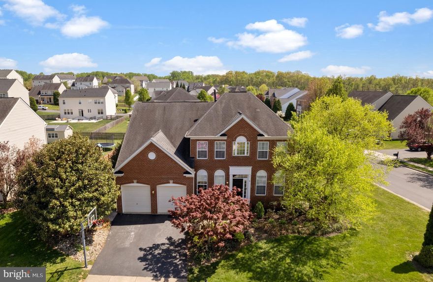 WOW, just WOW describes this home!!! This was the model home for the neighborhood and has all the bells, whistles and upgrades that you can imagine. It is one of the largest homes and corner lot in the neighborhood with 4 bedrooms at 3.5 baths and over 5000 sq ft! This impressive, beautiful, brick colonial will greet you when you arrive. When you enter this freshly painted home, the grand staircase will catch your attention. Beautiful hardwood floors are through-out the main level. There's ceramic tile in the sunroom to enjoy the natural sunlight. Every single detail and upgrade are on this level, triple crown molding through-out whole house, chair railing, custom wainscot panels, wine/coffee bar between the kitchen and dining room, tiled backsplash, lots of recess lightning, upgraded cabinet's, built-in desk, stainless steel appliances, and so much more. The separate formal dining room is the grandest of all, a perfect place for holiday dinners and get togethers. Relax in the cozy family room around the fireplace or just talk in the separate formal living room.  Enjoy your own office space with custom built-ins bookshelves. On the second level you will find the spacious primary bedroom with tray ceilings, triple crown molding. and huge walk-in closet. The primary bath with ceramic tile has a double vanity with jetted tub and separate shower stall.  You will certainly appreciate the laundry room on this level that's right beside the primary bedroom. You will find the other 3 beds and full bath on this level with a little reading nook and window to relax at. We can't forget the very open and roomy basement with a wet bar to entertain those guests. There's a separate area that could be used as a possible 5th bedroom and a FULL bath.  Two large unfinished rooms for storage and decorations. Walk out to the stairs that will take you to the large fenced in backyard with shed.  Enjoy those warm days on your patio under the pergola, which does convey. Seller prefers to close with Cardinal Tile.   Pool table, projector and screen can convey separately for the right price.