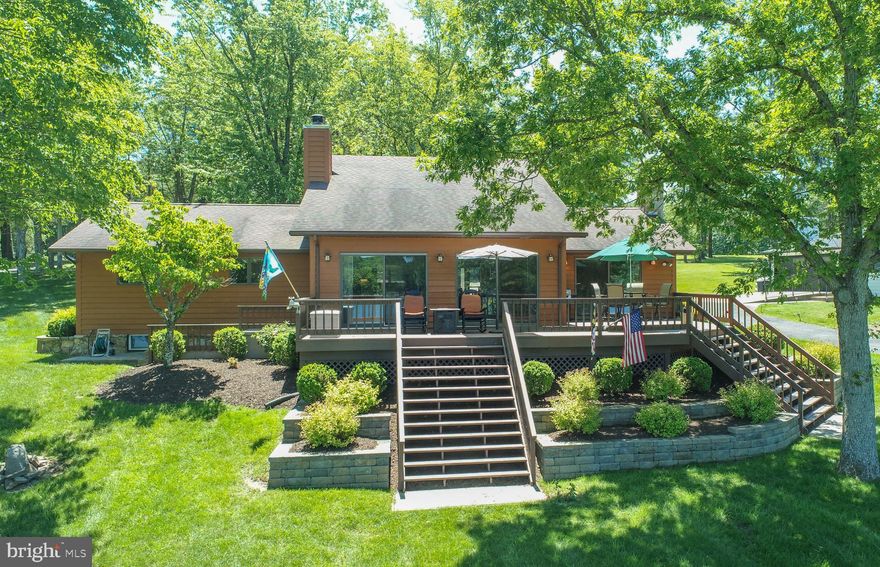 The exceptional lakefront at Deep Creek you've been waiting for! Deep water, a gentle slope down to the dock, open with a grassy lakeside yard, 100 feet of lake frontage, Type A private boat dock, and north west exposure for all day sun and dramatic sunsets! Meticulously maintained 4 bedroom, 3 full bath, 2-level home with a recently updated kitchen! Features include exceptional lake views from the living room and primary bedroom, recently re-finished hardwood floors, granite kitchen counters, stainless steel appliances, 2 fireplaces, and large lower level recreation room. The oversized lakeside deck is perfect for those summer days. Located on a quiet, no-through road. Don't miss out on this one!