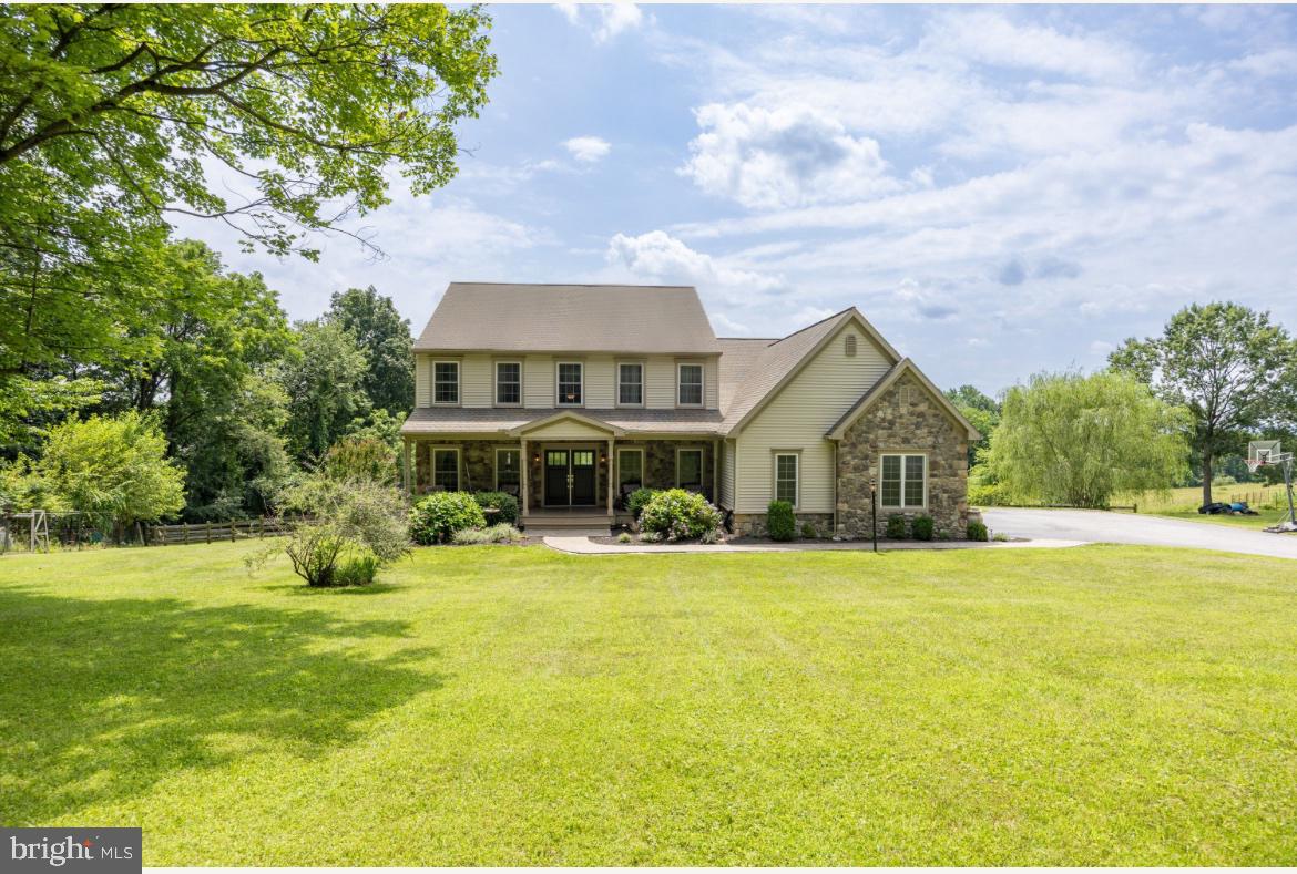 Welcome to 338 Black Horse Road, a stunning custom-built home offering over 4,400 square feet of thoughtfully designed living space on a private 5.2-acre lot in beautiful Chester County. Built in 2011 and meticulously maintained, this home blends elegance, comfort, and natural charm. A newly installed front walkway (2024) leads to a welcoming covered front porch and double entry doors that open into a bright two-story foyer. To the right is a spacious home office, and to the left, through a large arched opening framed by columns, is the formal dining room, which flows seamlessly into the dream kitchen. This impressive kitchen features ample white cabinetry, black quartz countertops, a center island, a double oven, cooktop, pantry, and a sunny breakfast area. The two-story family room is flooded with natural light from tall double-hung windows that flank a striking floor-to-ceiling stone gas fireplace with a wood mantle. A sliding glass door off the kitchen leads to a large maintenance-free deck that offers peaceful, sweeping views of the surrounding countryside.
On the mid-level, you’ll find a luxurious primary suite with two walk-in closets and a spa-like en-suite bath complete with a huge walk-in shower, private water closet, and dual vanities. Adjacent to the suite is a laundry room with a utility sink for added convenience. Continue up to an open loft-style flex space that overlooks the family room, then to three spacious bedrooms. Two share a Jack and Jill bathroom with a tub and shower, while the third is a princess suite with its own full bath. All bedrooms include walk-in closets. Brand new carpet was installed in 2025 throughout the family room, stairs, princess suite and second-floor hallway.
Going toward the lower level you will find a home theater room. The fully finished walk-out lower level, completed in 2022, features luxury vinyl plank flooring, a full bathroom, a bonus office or craft room, and rough-ins for a future bar or kitchenette. French doors open to a beautiful Italian stone patio beneath the deck, complete with an outdoor shower. The property includes a fenced yard with a chicken coop and enclosed run, a quaint storage cottage previously used for goats, a whimsical tree house, eight mature blueberry bushes, and fruit trees including two apple, two pear, and two peach trees, fire pit and pond.
Additional highlights include a central vacuum system, a Kinetico water filtration system, energy-efficient multi-zone geothermal HVAC, a new water heater (2025), and a two-car garage with two 50-amp EV charging outlets (one Tesla-specific and one universal) powered by a separate 100-amp breaker. For added peace of mind, the home has been pre-inspected. This home offers the perfect balance of indoor luxury and outdoor enjoyment in a peaceful, private setting, while being conveniently located close to Routes 100 and 401, schools, shopping, restaurants, and scenic Marsh Creek State Park.