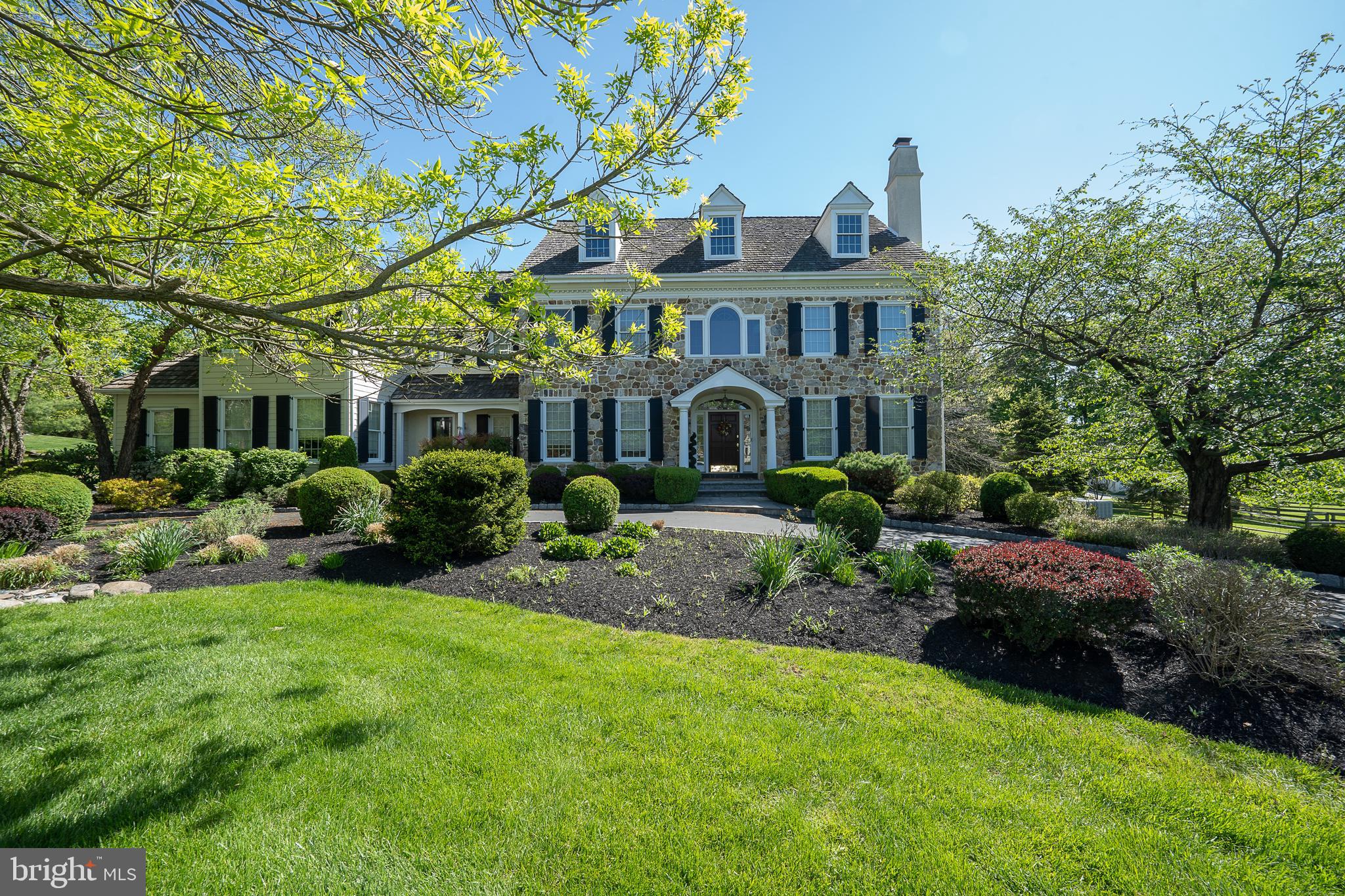 315 Blackburn is a stately stone manor home situated within the prestigious Main Line community of Saybrook. This custom home was designed by Anne Capron and built with the Bentley Homes signature of elegance and impeccable quality. Featuring 5 bedrooms, 3. 3 baths, 10 foot first floor ceilings and on site finished hardwood flooring, this timeless floor plan blends a relaxed charm of intimacy inviting family togetherness. The lot is professionally landscaped with lawns, perennial gardens and a graceful circular driveway to greet your guests. The first floor features a front to back center hall Foyer with a grand turned Staircase and landing. The Living Room and Dining Room display craftsman details such as two-piece crown molding, stately 7.5 inch baseboards and deep window sills. The Living Room fireplace has a floor to ceiling raised panel mantel. The handsome Study is detailed with natural cherry woodwork and a window seat. The designer Kitchen has solid wood cabinetry by Kountry Kraft and offers a large island with seating, plenty of counter space and a large pantry. The Wolf 6 burner cooktop, Wolf double ovens, Sub-zero refrigerator and Asko dishwasher will satisfy any foodie’s passion. The sun filled Breakfast Room has access to the rear flagstone patio. A Butler's Pantry with wet bar and wine cooler complete the entertaining hospitality. Designed for today’s lifestyle, the open Family Room has a full height field-stone gas fireplace and a full wall of built-ins. The “everyday” back foyer has a convenient 2nd powder room and Bentley's signature built in cubbies with coat hooks and shelving.
Ascending to the second floor you’ll experience luxury in the Primary Bedroom suite appointed with a Sitting Room, double walk-in closets , marble bath with glassed in shower, Jacuzzi tub, two separate vanity areas and a separate toilet room. The hallway leads to 4 additional Bedrooms, 2 more full Baths and the convenience of a second floor Laundry. There is a separate back staircase with overhead skylight that circulates back down to the Kitchen. Another set of oak stairs lead to the daylight, walk-out Lower Level featuring a Recreation/Game Room, Sitting/TV Area, temp-controlled custom cedar wine cellar and powder room. Copious storage abounds in the large unfinished area which houses a brand new high efficiency Carrier furnace and two 75 gallon high efficiency gas water heaters as well as 400 amp electric service. Other exceptional features include a whole house 36 kilowatt generator, a holiday light package with timer for all windows throughout, professional landscaping with perennial gardens, built-in lawn & garden irrigation system, stone patio and large flat rear yard for entertainment and play.
Saybrook's coveted location is convenient to major highways, upscale shopping boutiques, sophisticated dining and historic attractions. It is serviced by the award winning Tredyffrin/Easttown School District, known for its dedication to outstanding educational performance. Recognize an exceptional investment and come home to 315 Blackburn Drive.