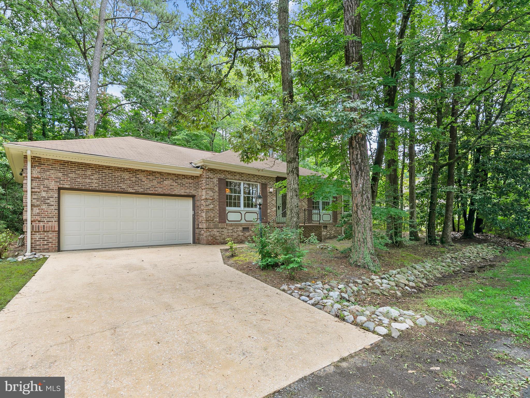 Welcome to this timeless traditional brick-front home in the heart of Ocean Pines, perfectly situated among mature trees and lush greenery for a sense of peaceful seclusion.
Step through the elegant double-door entry with decorative glass panels into a welcoming foyer adorned with hardwood flooring. To your right, a formal living room or office provides a versatile space filled with natural light. To your left, the formal dining room features classic crown molding and chair rail detailing, setting the tone for elegant gatherings.
The kitchen combines function and charm with white cabinetry, pull-out shelving, and striking royal blue quartz countertops that lend a coastal flair. A tile backsplash and double stainless-steel sink sit beneath a window offering lovely outdoor views. Luxury vinyl plank flooring adds durability and style. Stainless steel appliances complete the space, and there's room for a casual dining table. The laundry area is tucked conveniently into a kitchen closet, and direct access to the two-car garage adds everyday ease.
The cozy family room centers around a warm brick gas fireplace, ideal for relaxing evenings. The primary bedroom is thoughtfully placed at the rear of the home for added privacy and features a walk-in closet and an en suite bath with a double-wide shower stall complete with grab bars. Two additional bedrooms share a hall bath with a walk-in, raised-seat tub and tile surround—perfect for comfort and accessibility.
A screened porch at the rear of the home provides a tranquil spot to enjoy the surrounding greenery. Just outside, an outdoor shower adds a convenient touch after beach days or gardening. The hallway also includes pull-down attic stairs, offering easy access to additional storage.
The Ocean Pines resort community offers an impressive array of amenities that include, a championship golf course, scenic nature trails, five pools with aquatics programs, beachfront restaurant in Ocean City, yacht and beach clubs, marinas, a premier racquet sports complex, community activities throughout the year, farmers & artisans’ markets, gift shop and so much more.