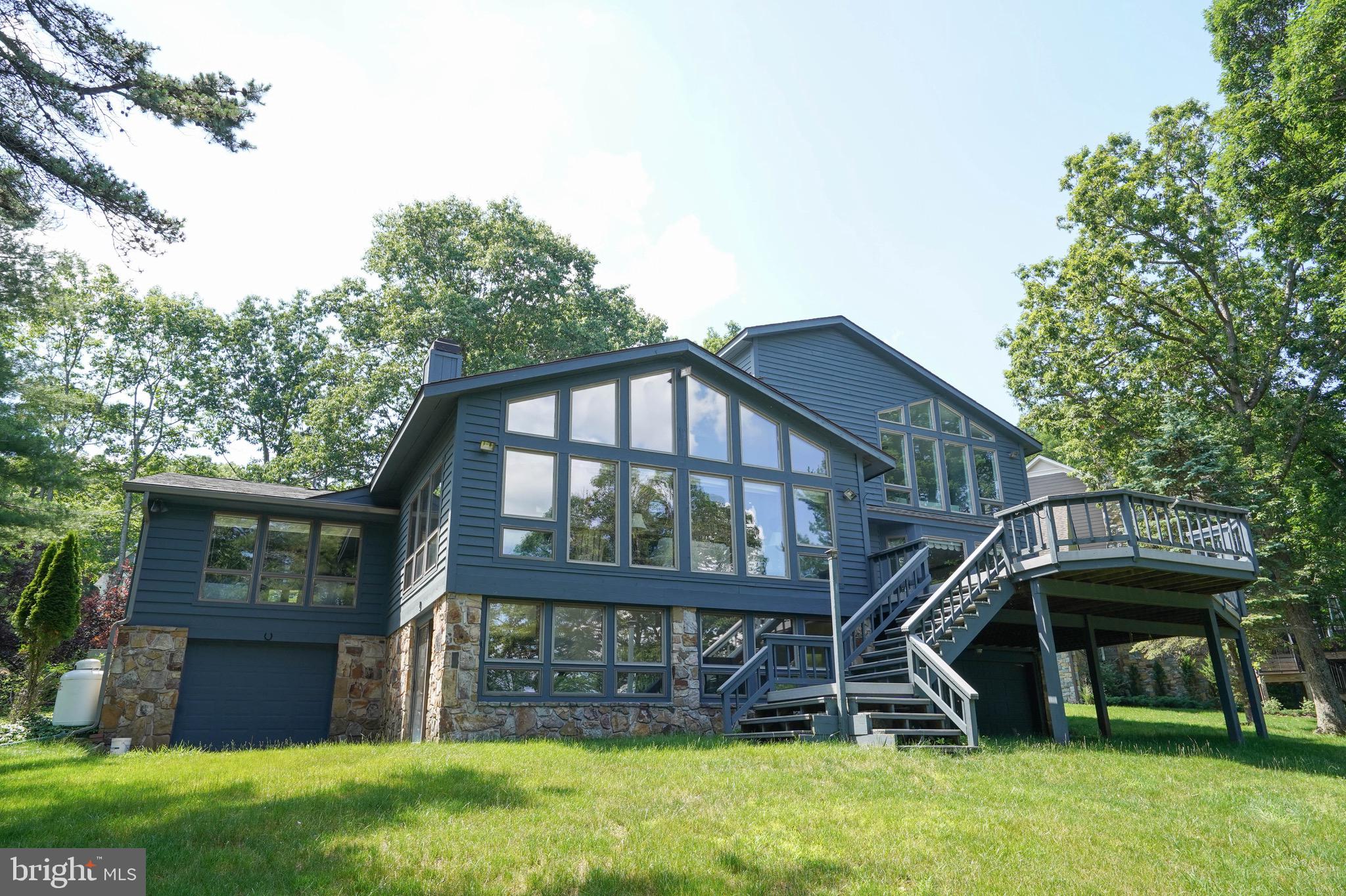 Panoramic lakefront living greets you on the point of this remarkable 4 bedroom, 4 bathroom lakefront home with 231' of premium lakefront facing east, offering amazing sunrises looking down a long stretch of the lake toward Turkeyneck! 1 oversize attached garage spaces offer plenty of space for your vehicles on the street side and 2 attached garage spaces provide room for your lake toys on the lower level. An expansive deck provides plenty of room for outdoor entertaining, and multiple living spaces inside provide plenty of room for guests to enjoy their time at the lake. The Type A dock sits in deep water, great for swimming and enjoyment. The home sites on a private road and is the next to last home on the street. The location is just minutes from all of the area's most desirable restaurants, golf courses and Wisp Ski Resort! Buydown has been purchased and conveys. Looking for an opportunity to own a premium waterfront home on one of the best settings at the lake? Call today to schedule a private tour!