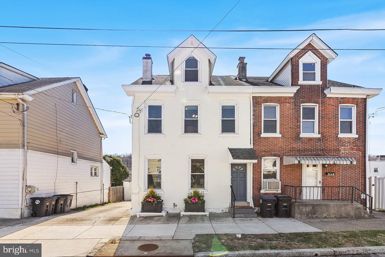 Welcome to 605 Spring Mill Avenue, a beautifully updated and spacious 3-bedroom, 2.5-bath twin in the heart of Conshohocken. With its classic white brick exterior, undeniable curb appeal, and a seamless blend of character and modern updates, this home is truly exceptional. Step into the inviting foyer, which leads effortlessly into a light-filled living and dining area, designed for both comfort and entertaining. The updated eat-in kitchen features stainless steel appliances, granite countertops, and durable vinyl plank flooring, offering both style and functionality. Just beyond, a laundry room, a well-placed half bath, and an enclosed back porch/mudroom provide convenient access to the driveway, detached garage, and private backyard retreat. Upstairs, beautifully restored hardwood floors extend throughout the second level. A newly remodeled full hall bath showcases custom tilework, a sleek vanity, and a tub. A sunlit guest bedroom sits adjacent to a luxurious new full bath, complete with a double vanity, elegant tilework, and a custom-built walk-in closet. At the front of the home, the expansive primary bedroom is bathed in natural light from three large windows, creating a serene retreat. The third floor offers a spacious and versatile area, ideal as a third bedroom, home office, playroom, or creative space. Outside, the landscaped backyard serves as a private oasis, featuring a fire pit- perfect for gatherings. The one-car garage is equipped with an electric vehicle charging plug, and the extended driveway provides ample parking. Additional highlights include custom window treatments, an automated irrigation system for the front planters, and a freshly painted interior. Perfectly positioned within walking distance to Fayette Street’s restaurants, shops, and bars, this home is just steps from the SEPTA train station for an easy commute. With quick access to 76, 476, 202, and 276, the location is truly unbeatable.