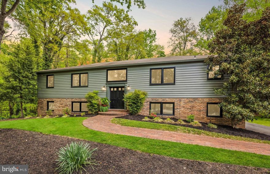 You'll love living at  this stunning residence in the charming River Bend Estates community. This meticulously updated home seamlessly blends classic design with modern finishes, and offers a private sanctuary for tranquil living tucked between two National Parks. Backing directly to historic Fort Hunt Park the property offers a serene and private oasis approximately 15 miles from bustling Washington DC.  Enjoy a peaceful commute on the George Washington Parkway.  As you step inside, you can’t help but stop to take in the treetop views through the new Pella windows. Sunlight glistens off the hardwood floors that flow throughout the open-concept main level with a spacious living room and dining area, perfect for entertaining. The remodeled kitchen is a chef's delight, featuring premium leather finish quartzite countertops, upgraded stainless steel appliances, and ample sourced cabinetry. The home offers four generously sized bedrooms and updated baths with beautiful modern fixtures and tile. The primary retreat includes a fireplace, en-suite bath and walk-in closet. On the lower level a large versatile room can be used as a bedroom, a large office, or a dedicated studio space. The limestone floors of the family room set the tone for an inviting and cozy family room that opens to a serene backyard oasis, twinkle lights included. An oversized 2-car garage and workshop complete the space. Enjoy sunset strolls along the Potomac River or walk through history in Fort Hunt Park, this home seamlessly combines location, tranquility, and modern . living, offering the perfect setting for your forever home. Welcome to a lifestyle of serenity and sophistication.