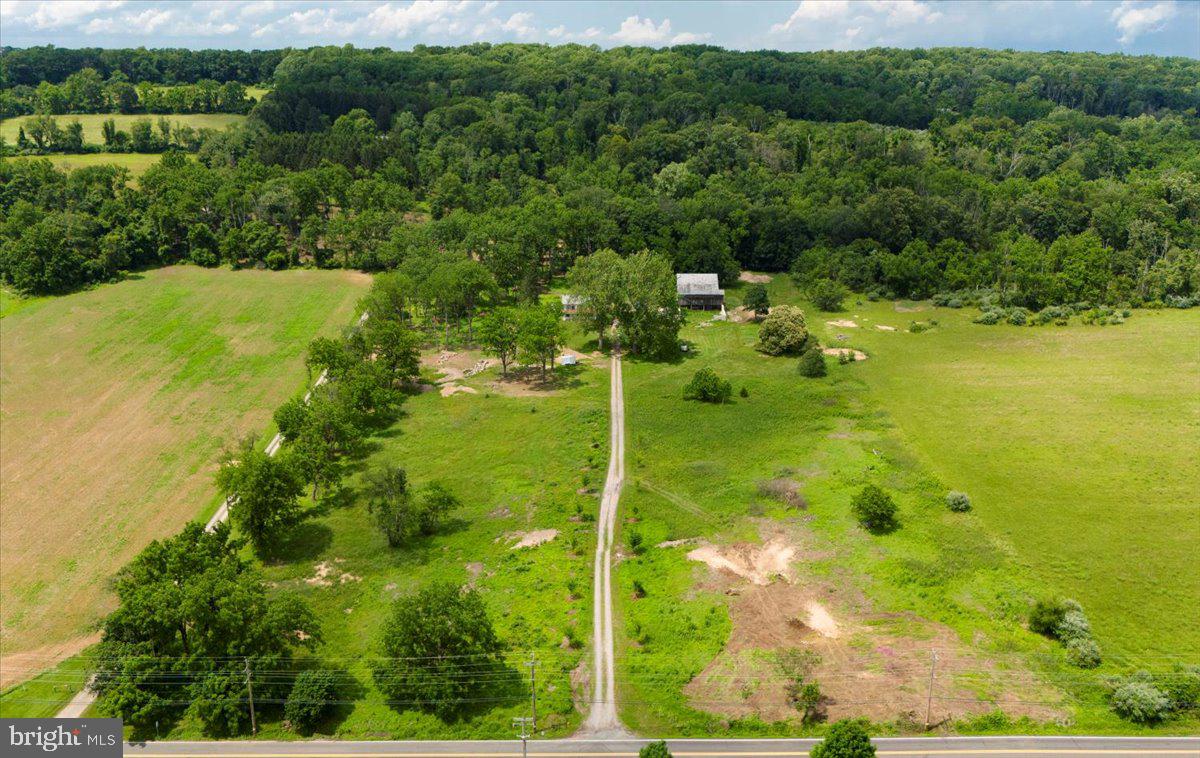 Located on 15 acres in Solebury countryside and only minutes from downtown New Hope, Primrose Farm presents a substantial restoration opportunity. The fieldstone farmhouse maintains its architectural originality. The main residence is accompanied by additional buildings, including a three-story stone bank barn, a two-story carriage house, a stone root cellar, and a smokehouse, each contributing to the property's historic character. The fieldstone porch offers views of two centuries-old sycamore trees, and the fieldstone enclosed pasture provides space for outdoor activities. The natural landscape supports wildlife and the fields may be used for gardening or leisure pursuits. The property is protected by a conservation easement, ensuring privacy and tranquility. This rare opportunity in Solebury presents a significant project for buyers interested in a Bucks County estate opportunity to develop your own family compound !