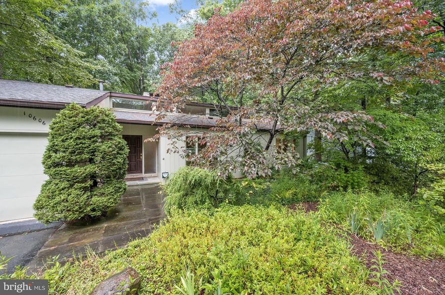 Masterfully remodeled and exquisitely maintained, this Mid-Century Modern Rambler residence boasts incredible scale, beautifully updated interiors and meticulously maintained exterior amenities to offer luxurious living across 2 perfectly appointed levels. Breathtaking design notes are on display throughout the 5 Bedroom, 3.5 Bathroom home to include cathedral ceilings, gleaming hardwood floors and a multitude of skylights that flood the interiors with natural light. Outdoors, an abundant natural perennial garden welcomes you and the peaceful sounds of the backyard pond and waterfall can be heard from the renovated Trex Deck or Lower Level Screened Porch to offer an idyllic respite just outside our nation’s capital. Set on nearly .3 acres and backing to beautiful parkland vistas, the one-of-a-kind Rambler is sure to delight even the most discerning of buyers. 
The Main Level showcases the pinnacle of one level living with exquisitely expanded and thoughtfully appointed Living and Dining spaces. The spacious and light-filled living area is highlighted by a stunning two-story, free-standing stone fireplace – a real showstopper! The Gourmet Kitchen is truly the heart of this home, boasting custom cabinetry, granite counters, Kitchen Aid appliances, and an added adjacent Breakfast Room with woodland views, this exquisite Kitchen is sure to please any caliber chef. These magnificent gathering spaces all offer direct access to the delightful rear Trex Deck, providing the perfect setting for al fresco dining and entertaining overlooking the spacious, fully fenced backyard. Privately situated, the Main Level Bedroom wing holds the expansive Primary Suite, complete with clerestory windows, sitting area, and a walk-in outfitted closet. The renovated and expanded spa-like Primary Bathroom is an oasis of its own, boasting dual vanities with granite counters, skylights, Kohler jetted soaking tub and a stall shower with dual shower heads. Two additional Bedrooms, and a handsomely renovated Hall Bathroom complete the Main Level’s offerings. 
The multifunctional, walkout, Lower Level features a spacious Recreation Room with an eye-catching free-standing stone fireplace and direct access to the charming screened porch. The delightful Screened Porch is the perfect setting for summer gatherings and leads to the private and picturesque rear yard. 2 Bedrooms, each with abundant windows and closet space as well as a recently renovated Full Bath are also located on the Lower Level. A Walk-In storage closet, a Laundry/Utility Room with new Whirlpool Washing Machine, extra Freezer and Refrigerator, Utility Sinks, Cabinets and Counter Space are conveniently appointed next to the unfinished Workroom and complete the Lower Level’s offerings.