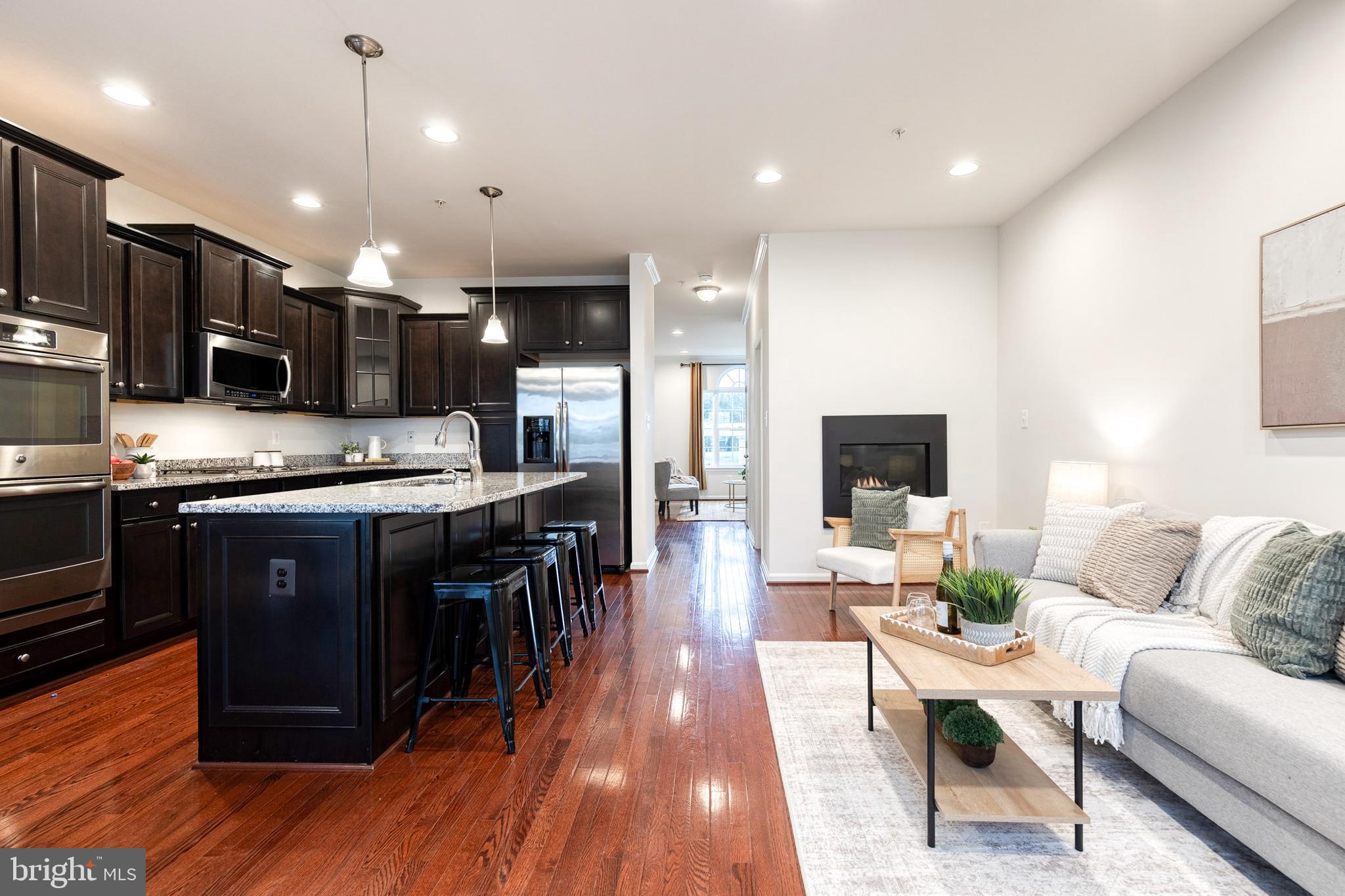 Don’t miss this stunning brick-front, expansive 2013 townhome in pristine condition, located in the sought-after Pointe at Arundel Preserves! Step inside to a welcoming foyer featuring beautiful dark hardwood floors and sun-filled large windows. The main entry level boasts an open-concept floor plan complete with a spacious living room, cozy gas fireplace in a second seating area off the kitchen, dining area, and a gourmet kitchen designed for both everyday living and entertaining. Enjoy stainless steel appliances, quality cabinetry, and little luxuries like a double oven, and a large center island with breakfast bar and in-island sink. Slider doors off the kitchen lead to a private deck — perfect for grilling or relaxing in fresh air outdoors. Upstairs, you’ll find three generous bedrooms, each with ample closet space and large windows for natural light, plus a full hallway bath with tub shower and convenient laundry area. Head to the luxurious primary suite, featuring a tray ceiling with fan, walk-in closet, and large en suite with a dual sink vanity and a walk-in shower. The lower level offers flexible living space ideal for another family room, home office, or gym, along with a half bath and direct access to your private two-car garage. Fresh paint throughout enhances the home’s modern appeal. Extra bonus information: the HVAC has always been regularly serviced, the air ducts have been cleaned, and there is a Sump pump with a battery backup. This home has been extremely well cared for and maintained with all of the best options! Enjoy incredible community amenities, including a pool, tot lots, walking paths, community center, and more! Conveniently located near shopping, dining, BWI Airport, Arundel Mills, Maryland Live Casino, and with easy access to 695, 95, 100, and other commuter routes. This home combines style, comfort, and unbeatable location — it’s move-in ready and waiting for you!