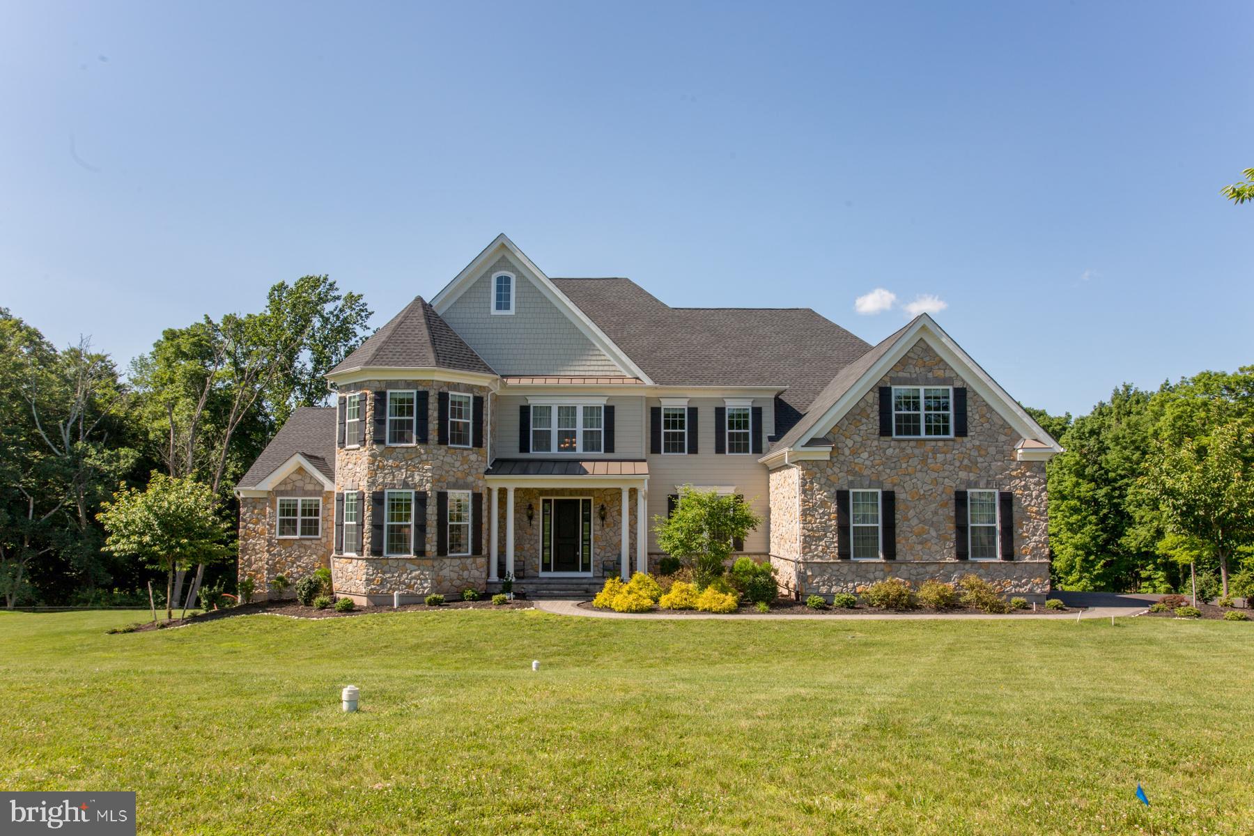 This magnificent home is Toll Brothers' Henley Country Manor, loaded with all of the upgrades. Entering the double front doors, you'll see a beautiful butterfly staircase with wrought-iron railings. The floors are ivory marble tiles. From the foyer, the open floor plan allows you to view the cathedral height family room, as well as the living and dining rooms, lined with beautiful wainscotting, thick crown moulding on the 10' high ceilings, and gorgeous dark brown engineered wood floors. The family room is open to kitchen and has a back staircase. The gourmet kitchen boasts beautiful soft white cabinetry, a huge island, granite countertops, commercial grade appliances, and a walk-in pantry. Off the kitchen is a mudroom with white cabinetry, a laundry room, and a three-car garage. This house boasts TWO luxurious master bedroom suites, each with a private sitting room and a spa bathroom with a Roman tub, double vanities, and private toilet closet. In total, the second floor has four large bedrooms and four full baths. The extra-wide space over the garage includes two large walk-in closets and an office space, or more closet space. The walkout, daylight basement is 80% finished, with plenty of storage. It has 2 rooms to be used as flow-over bedrooms or bonus rooms, as well as a very large open space. A completely sound-proof room houses a projector, large screen, and speakers, all negotiable with the buyer. Outside the sliding doors is a private patio with view of woodlands. Included with the house is a whole house generator, humidity control system, and water conditioner.