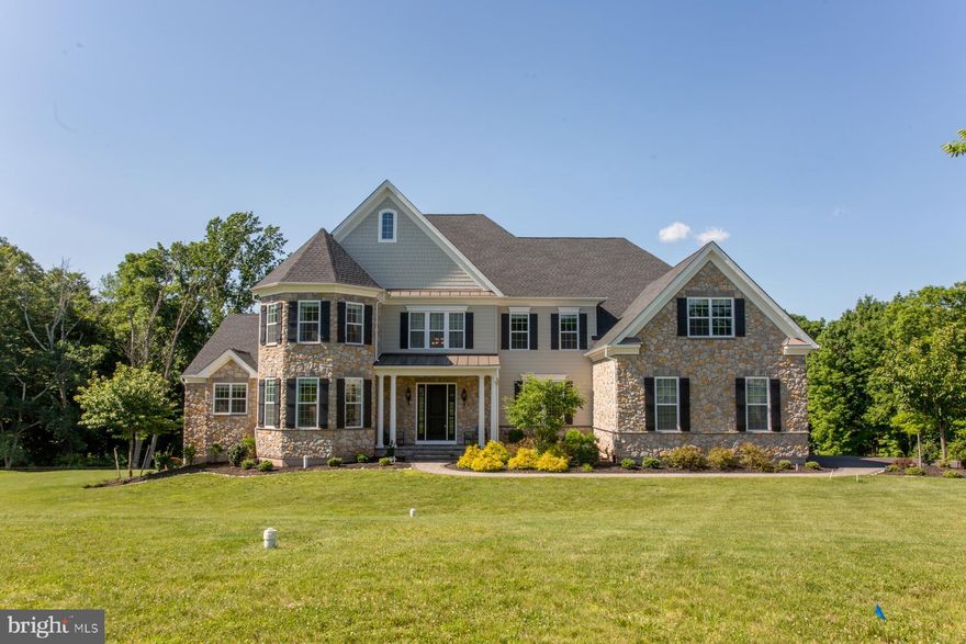 This magnificent home is Toll Brothers' Henley Country Manor, loaded with all of the upgrades. Entering the double front doors, you'll see a beautiful butterfly staircase with wrought-iron railings.  The floors are ivory marble tiles.  From the foyer, the open floor plan allows you to view the cathedral height family room, as well as the living and dining rooms, lined with beautiful wainscotting, thick crown moulding on the 10' high ceilings, and gorgeous dark brown engineered wood floors.  The family room is open to kitchen and has a back staircase.  The gourmet kitchen boasts beautiful soft white cabinetry, a huge island, granite countertops, commercial grade appliances, and a walk-in pantry.  Off the kitchen is a mudroom with white cabinetry, a laundry room, and a three-car garage.  This house boasts TWO luxurious master bedroom suites, each with a private sitting room and a spa bathroom with a Roman tub, double vanities, and private toilet closet. In total, the second floor has four large bedrooms and four full baths.  The extra-wide space over the garage includes two large walk-in closets and an office space, or more closet space.  The walkout, daylight basement is 80% finished, with plenty of storage.  It has 2 rooms to be used as flow-over bedrooms or bonus rooms, as well as a very large open space.  A completely sound-proof room houses a projector, large screen, and speakers, all negotiable with the buyer.  Outside the sliding doors is a private patio with view of woodlands.  Included with the house is a whole house generator, humidity control system, and water conditioner.