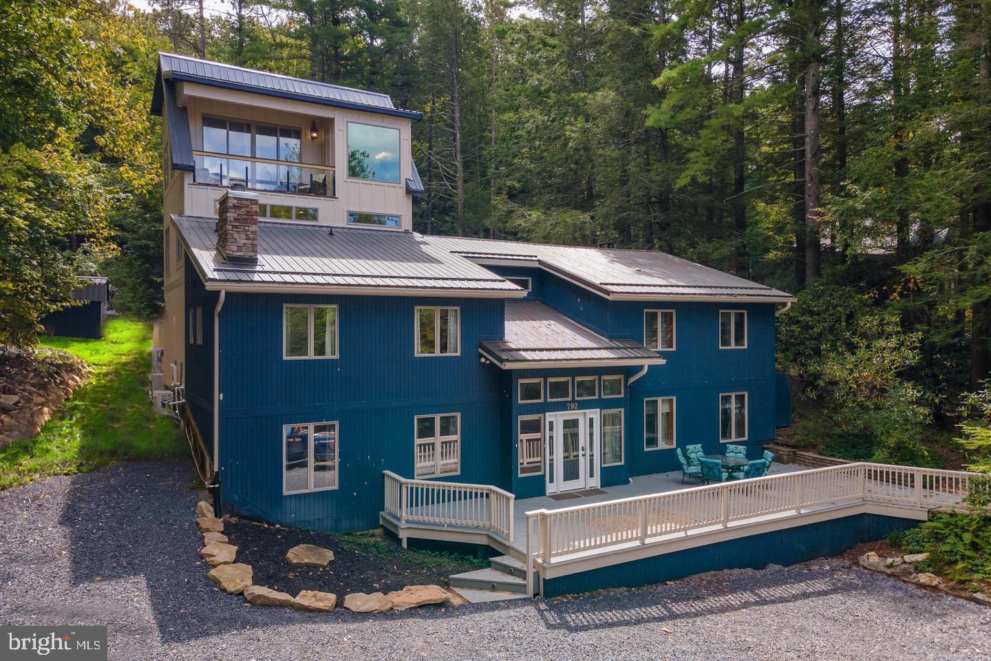 Fully Renovated Lake Front Lodge with Private Type-A Dock – This 8 Bedroom, 6.5 Bath Lake Front property has been completely re-imagined with 2700 sq ft of newly added living space, indoor pool, and home theatre! Fully finished lower level with a primary suite and living room equipped with an island bar and stone fireplace. Bright and shiny new kitchen with stainless appliances, wine chiller, 2nd refrigerator, and quartz tops. Gorgeous modern bathrooms, with updated vanities, tiled showers, and multiple standing tubs. Sold “turn-key” fully furnished with updated fixtures and furniture throughout! “Great Hall” style dining room with its a stone fireplace. Sprawling front deck overlooking Deep Creek Lake. Decked-out covered back patio with abundant outdoor seating. Lakeside fire-pit with perfect level lake access. Right across the street from Deep Creek Lake State Park, and minutes from local restaurants and Wisp Resort. Offering the perfect blend of comfort, style, and convenience, “Blue Anchor” makes an excellent lake home, or a perfect vacation rental too. Call today to set up your private showing!