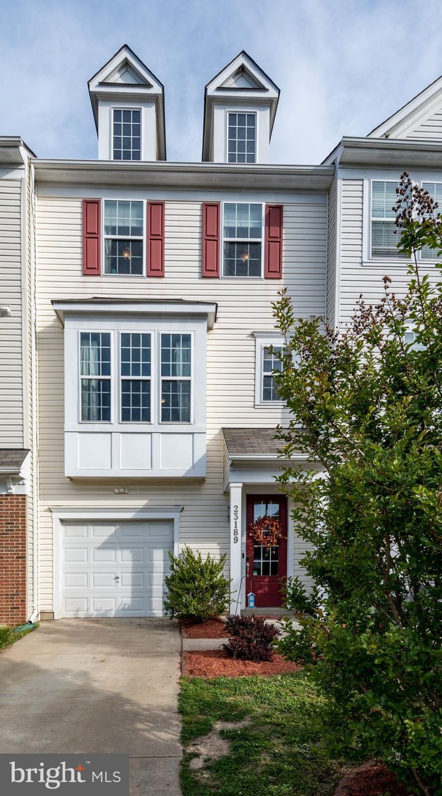 Welcome home! Just inside the front door is an open entry level floor plan with hardwood flooring, bedroom/family room, full bathroom, access to the 1-car garage with opener, and sliders to the back yard. The hardwood flooring has been carried up the stairs to the main level, where you'll find an open floor plan with living room, half bath, large kitchen/dining room, and sliders that lead to an extra large deck added by a custom builder - with secured canopy room and lighting. The living room features matching laminate, making the majority of this townhome flooring a breeze to clean! The stairs to the upper level are carpeted and lead to three bedrooms, two full baths, and a laundry room. The washer and dryer will convey with this home. Enjoy all of the amenities this community offers year round, with a community pool, walking trails, and more!