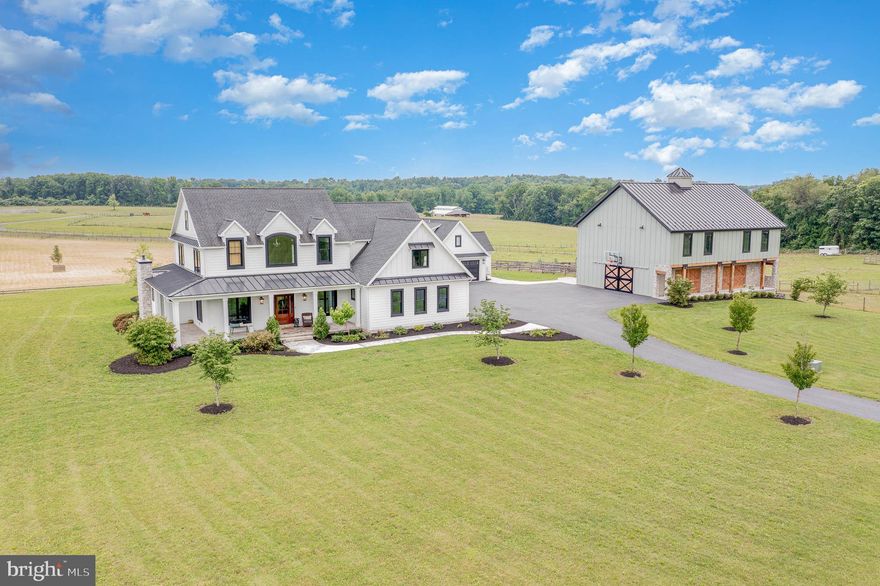 Experience the ultimate in relaxation and privacy at this stunning farmhouse situated on just under 7 acres. As you arrive down the long driveway, stunning pasture, fields, and serenity awaits. This custom FoxBuilt home boasts large rooms filled with natural light. You will appreciate every high-quality detail, including gorgeous hardwood floors, brick accents, shiplap, exposed beams and beautiful stone, all giving this exquisite property a warmly inviting ambiance. The open concept design enables effortless entertaining and relaxation with an abundance of windows allowing panoramic views of the surrounding vista. The main floor features an oversized gourmet kitchen that offers a huge walk-in pantry, granite counters and an island for seating.  The kitchen is open both to a large dining area with a stone fireplace (wood burning), and a spacious family room that also has a fireplace (propane). The second floor houses a luxurious primary suite that includes a lavish bathroom and a large walk-in. Bedroom 2 and bedroom 3 share a jack and jill bath, while bedroom 4 (known as the bunk room) has its own large private bath.  The basement features a theater room for enjoying your favorite movies, a wet bar with beautiful crafted stone, and plenty of additional space for entertaining. There is also a 5th bedroom in the basement with an adjoining bath.  Enjoy the ultimate outdoor living experience with an outdoor bar area featuring a built-in grill, an expansive patio, and fire pit. Off the main house awaits a 3-bedroom inlaw suite complete with its own kitchen, 2 bathrooms and laundry.  The guest house also has an additional 2 car garage - perfect for guests or family members coming from out of town. Additionally, there is an oversized barn and a loft area for additional storage or workspace, all providing ample storage for toys, and farm equipment.  For horse enthusiasts, a 6-stall barn. For the farm enthusiasts, your opportunity awaits having a pasture , completely fenced and ready for use. This Farmhouse presents an exceptional opportunity to own a truly remarkable property built by FoxBuilt. With its luxurious features, prime location, and impeccable craftsmanship, this residence is ready to welcome you into a world of comfort, style, and timeless beauty.
1st/2nd Floor: 3,713sqft
Full Finished Basement 1,600sqft
In-Laws Quarters: 1,108sqft