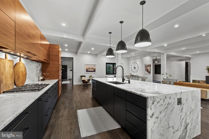 Please arrange a private showing! Welcome to 3410 Woodvalley Drive, an unrivaled mid-century modern residence where light, design, and craftsmanship come together. In 2018, the home underwent a full architectural renovation, reconstructed from the inside out with enduring comfort and no detail overlooked. Designed for long-term living rather than resale, every feature blends function and luxury. Passive-solar orientation allows winter sunlight to warm the interiors while roof overhangs limit summer heat. Inside features 10-ft ceilings, exposed beams, wide-plank flooring, and full-height interior and closet doors that stretch nearly floor to ceiling, enhancing the home’s vertical lines and airy feel. The chef’s kitchen includes Wolf, Sub-Zero & Bosch appliances, dual ovens, a five-burner gas range with custom hood, quartzite waterfall island, lift-up cabinetry, hidden outlets, and a drawer-style microwave. The primary suite offers two custom closet systems with built-in drawers and shelving, heated radiant floors, an oversized rain shower, ROHL fixtures, his-and-hers vanities, and custom blackout shades. Additional bedrooms have large windows, sliding barn doors, and built-in closet systems. The mudroom/laundry functions as a secondary prep space and butler’s pantry with deep sink, extra refrigerator, and custom cabinetry. Utility features include a full-home water filtration system and a tankless water heater. The 0.63-acre lot features full yard irrigation, original stone retaining wall with steps to the upper lawn, a six-foot custom wood fence (2023), a glass-door two-car garage, and an attached second storage garage. Architectural up-lighting showcases the home after dark. The backyard offers space for future amenities such as a pool or putting green, while preserving open green space. Modern California living, timeless elegance, and thoughtful design all come together here, a home this intentional and refined is rarely available in Woodvalley.