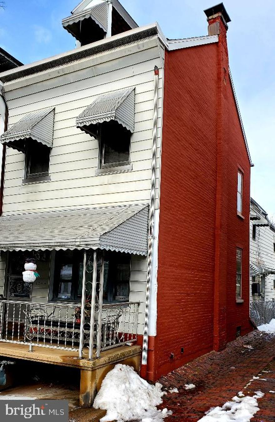 Lovely end of row with covered front porch and off- street parking. Home offers full baths on 1st floor and 2nd floor.    Nice kitchen layout with gas cooking and double bowl sink. Second floor has 4 bedrooms (some are walk thru) with closets and rear bath. Full unfinished basement with wood stove and economical gas heat. Attic is unfinished and offers plenty of storage space. Great fenced in rear yard with access to off street parking through the side alley.  With cosmetic updates, you can make this home shine. Home is being sold in "as is" condition. Inspections are for buyers information only. One Yr Home Warranty being offered with acceptable offer. Good investment and priced to sell.