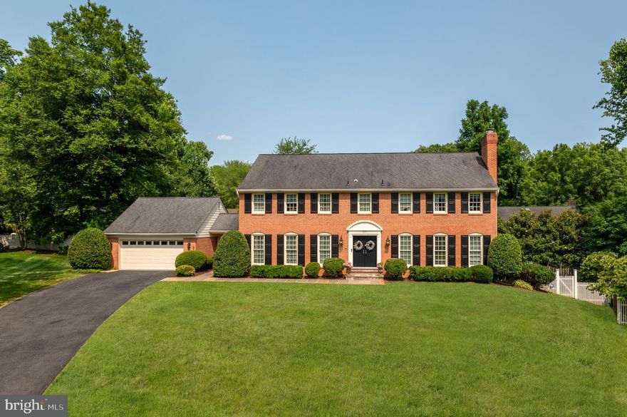 Sited on a private cul-de-sac in McLean’s Timberly neighborhood, 1171 Huntover Court is a 1977 brick Colonial boasting beautiful upgrades and elegant design details across 3 levels and 5,900 total square feet. Nestled on nearly half an acre, the outdoor amenities are as stunning as the home’s interiors. Showcasing a walkout Main Level Deck and Lower-Level Patio, the residence’s outdoor entertaining spaces provide the perfect respite while overlooking the lush greenery and mature trees of the fully fenced rear garden. Offering 5 Bedrooms and 4.5 Bathrooms throughout an open floor plan, the interior living spaces include gleaming hardwood flooring, detailed moldings and wainscotting, and large windows allowing in lots of natural sunlight. 
The front flagstone path surrounded by boxwoods leads you into the entry foyer with new marble floors, which is flanked by the Living Room with fireplace. The Gourmet Kitchen offers direct access to the formal Dining Room with views of the front garden and western sunlight. Upgraded with high-end stainless-steel appliances and boasting 2 sinks and ample counter space, the kitchen opens to the Breakfast Room and the expansive Family Room with built-ins, a fireplace, and direct access to the rear deck and garden, as well as the separate Main Level Office/Den. A conveniently appointed Laundry / Mudroom offers interior access to the attached 2-Car Garage. 
The Upper Level showcases the home’s principal guest quarters to include an expansive Primary Suite. Boasting gleaming hardwood flooring, 2 walk-in closets, a Sitting Room/6th Bedroom and a spa-like Bathroom complete with jetted spa tub, luxury steam/sauna shower and dual vanities, the Primary Suite includes views of the rear garden with eastern sun exposure. Three additional Bedrooms, each providing ample closet storage, and 2 Full Bathrooms are located on the Upper Level. 
The multifunctional, walkout Lower Level features a sprawling Recreation Room and Billiards Room, complete with Wet Bar and Gas Fireplace, that opens to the residence’s spacious Rear Patio for more informal entertaining. An additional Bedroom and Full Bathroom are located on this level as well as a large Storage/Utility Room and walk-in cedar closet.