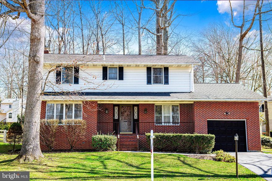 Welcome to this charming porch-front brick Colonial, offering a bright and functional layout. The main level begins with a tiled entryway and coat closet, leading to a spacious formal living room filled with natural light and plantation shutters. The formal dining room features hardwood floors and ample space for gatherings. The kitchen spans the rear of the home with an eat-in area, double oven, built-in microwave, and electric cooktop, and opens to the family room with a gas fireplace, striking brick accent wall, and sliding doors to the rear deck. A powder room and a screened-in porch—providing access to the garage complete the main level. Upstairs, you’ll find four generously sized bedrooms with good closet space throughout. The hall bath includes a double vanity and tub/shower combination, while the primary suite features two double-door closets and a private bath with a tub/shower stall. The fully finished basement provides a large, open recreation space with a custom hand-painted mural, along with a powder room, laundry area, and abundant storage. Walk-up stairs lead directly to the backyard, which offers a nice tree-lined setting with a comfortable amount of outdoor space. Recent updates include a roof approximately 8 years old, newer sliding doors, and a gas furnace and electric water heater replaced about 6 years ago.