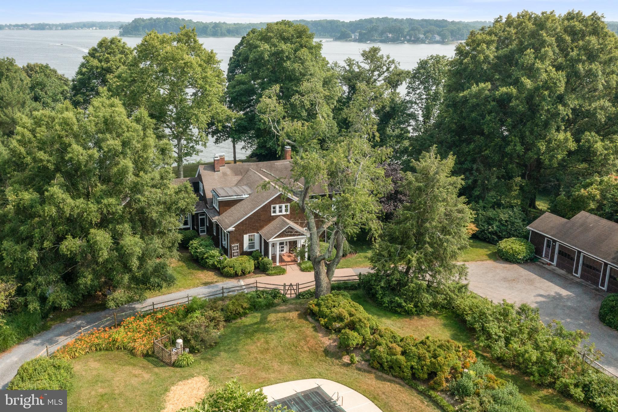 Reminiscent of storied summer homes, Wimbledon House is carefully sited on 2.5 acres on a high bluff facing southeast and offering water views looking down the South River to the Chesapeake Bay. This historical Annapolis property was the original home for all of Wimbledon Farms that was designed and built 103 years ago by Baltimore business man Harry Norris and enjoyed by his family for five generations. Walk through the front door and step back in time to an era of a simpler living. Elegant, yet understated, this transitional shingle style home exudes character and charm. The hallmark of this residence is the magical three season room that spans the back of the house with its wall of windows capturing bay breezes and activity on the water while providing the inner ambiance of waterfront living. The inviting living room with its two stone wood burning fireplaces and the gracious dining room, both with wood floors and beamed ceilings enhance the home's appeal. Embraced by canopied trees, colorful plantings and abundance of nature, this sprawling property offers approximately 325 feet of water frontage with 2 possible dock sites available, an inground pool, a detached 3-car garage and a long circular drive. A deep water protected pier is available in the community marina. A 2023 Perc Test is already in hand for a new large home. Truly a rare opportunity for another family to own a piece of history and create their own lasting legacy. Property being sold "As Is". No repairs will be made by Sellers.