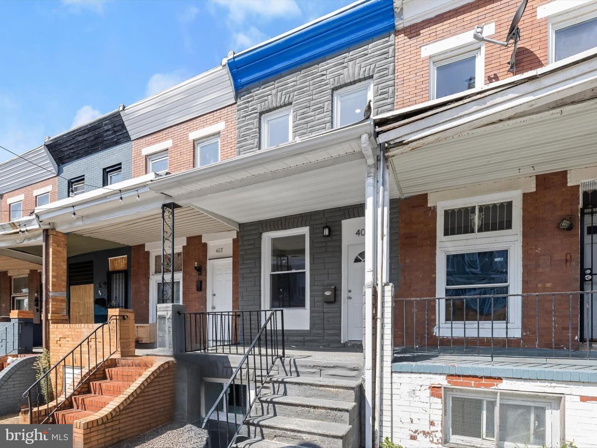 Welcome to 404 N Robinson Street, a beautifully renovated home that blends timeless charm with modern finishes and an urban flair. Perfectly positioned just around the corner from Ellwood Park and within close proximity to Johns Hopkins, this gem offers both convenience and style. Rich hardwood floors flow seamlessly throughout the main and upper levels, complementing an open-concept main floor with a light-filled living room and casual dining area. The stunning kitchen boasts sleek stainless steel appliances, a striking waterfall center island with breakfast bar, decorative backsplash, and access to the fenced rear patio ideal for outdoor gatherings. Upstairs, you’ll find two spacious bedrooms, each with hardwood floors and en-suite full baths. The top level opens to a rooftop deck with city views, while the finished lower level offers a family room, third bedroom, full bath, and laundry. Additional highlights include a covered front porch, fenced rear patio, and that coveted rooftop retreat. Some photos have been virtually staged