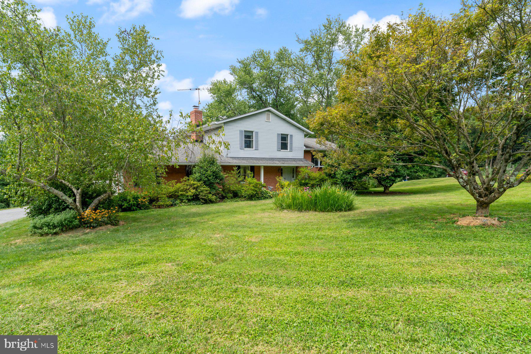 This spacious 4-level split home provides distinct living areas while maintaining an open and connected feel. The design provides privacy for the bedrooms while allowing for easy interaction between the main living spaces, making it ideal for both everyday living and entertaining guests. Enter into a welcoming foyer that opens to a large family room, featuring a cozy wood-burning fireplace. The family room provides easy access to both the garage and to a screened porch, where there is access to the updated maintenance free deck—perfect spaces for all your outdoor enjoyment. Conveniently located on this level is a half bath and a well-placed laundry room for added convenience. A few steps up from the family room are the eat-in kitchen, living room, and dining room, providing a great flow. Upstairs, you'll find the bedroom level, which includes a generous size primary bedroom with two closets and a private bath. In addition, there are two more well-sized bedrooms and a beautifully designed updated hall bath. The lowest level is an unfinished basement with an exit to the outside and access to a crawl space, offering plenty of potential for customization and storage. Outside, the home features a charming front porch, lots of room for gardening & play, a fishpond, a 2-car side-entry garage plus large driveway apron for expanded parking - and is situated on a desirable corner lot in a quiet cul-de-sac, offering both privacy and desirability. Utilities include private well and septic, heat pump with oil back-up and central A/C. Some updates within the past 12 years include roof, HVAC, HWH, re-lined chimney, maintenance free deck & reglazed tub in primary bath. This home has been well-loved, but it does require some TLC & updates, offering a wonderful opportunity to customize and make it your own.