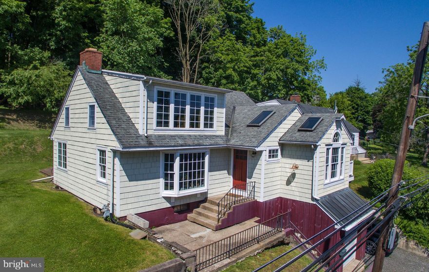 Downtown historic New Hope Borough, tucked away on a residential side-street yet just steps to everything including fine dining, entertainment, and shopping, this charming cape/colonial style home has been fully renovated with historical touches such as reclaimed hand hewn and rough sawn beams, with every modern convenience.  A large, main living-level primary bedroom features a walk-out deck to the flat side yard, en suite bath with Jacuzzi tub and walk-in shower, full laundry and double vanity, immediately adjacent to the open plan living/dining room with wood burning fireplace, exposed beams and modern gourmet kitchen (featuring high end stainless steel SubZero and Wolf appliances, gas cooking, and custom cabinetry).  Full of natural light, with skylights and high ceilings in many living areas, enjoy your perch on the hillside just above Main Street.  The second level offers three additional bedrooms (one of which lends itself perfectly as the primary bedroom if maximizing main level living space is your preference), and the walk-out garage level has additional space ready for finishing.  Located in the highly desirable NHS SD, close to major commuting roads to NJ/Philly/NYC and the greater Delaware Valley and Jersey Shore areas, this one is not to be missed!