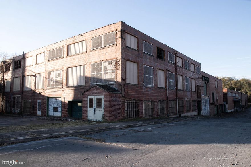 NATIONAL FRUIT:  Built in 1857 by John Quincy Adams Nadenboush as a small distillery, and destroyed by Union troops.   Purchased by Henry  Hannis in 1867, it became the Hannis Distillery.  This property is 19.42 acres inside the City Limits of Martinsburg included in the Historic Overlay, and an Opportunity Zone.  With historic tax credits available for restoration, this property has extensive possibilities.  Easy access to I81 with direct access to Tavern Road. Phase 1 Environmental is completed with reports available, but will need results updated. Currently zoned Mixed Use/Commercial,  the building are ready for renovation/re-use possibilities.  Some existing building could be renovated into apartments or commercial/retail.  Fabulous opportunity to create a micro-community inside the city limits.  Be creative! Public Water, Sewer and Natural Gas Available.  Due Diligence Please.