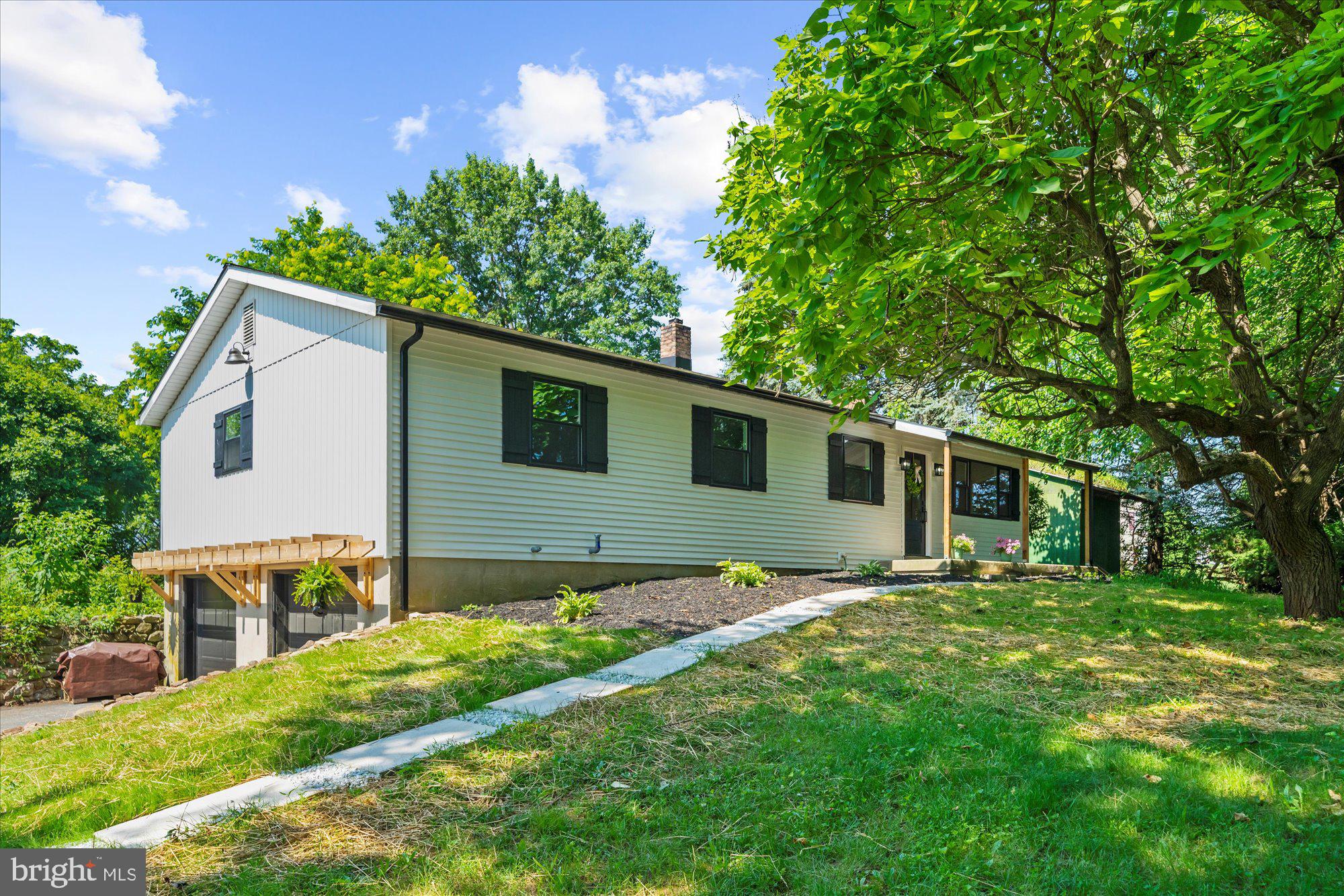 Welcome to 261 Indian Lane, a beautifully renovated 4-bedroom ranch home with modern farmhouse charm and an abundance of extra space. Step inside to a spacious living room featuring a large picture window that fills the space with natural light. The main floor offers four comfortable bedrooms and an updated kitchen that’s sure to impress, complete with striking green cabinets, granite countertops, and a butcher block-topped island providing extra storage and workspace. Just off the kitchen, you'll find a sunken family room that flows into an additional bright and versatile room with a wall of windows—perfect for a home office, hobby space, or oversized mudroom with views of the greenhouse. A second set of stairs leads from the family room down to the partially finished basement, where you’ll discover a generous rec room, a bonus room, and a convenient half bath that also includes laundry hookups. Outside, this property is ideal for anyone dreaming of their own homestead oasis. Several small outbuildings offer endless possibilities, and the private yard provides a peaceful, secluded setting. This property truly offers a multitude of options and opportunities. You must come and see this one for yourself!