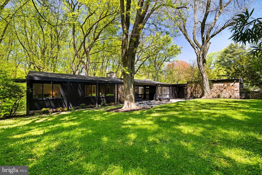 “Tulipwood”, the stunning Mid-Century Modern home & property of architectural, cultural & historical significance is being offered for sale on the open market for the first time ever! Includes 8/13 of 4100-4 Apalogen Rd (8/13 of a 1.23 acre lot on right side of home). Designed & built in 1954 by landmark architect Elizabeth Hirsh Fleisher as the home & residence for her & her husband, noted landscape architect Horace Teller Fleisher. Elizabeth Hirsh Fleisher was the first licensed woman architect in Philadelphia & one of the first in PA. Elizabeth is noted for designing Parkway House in 1952, one of the first post-war luxury apartment buildings in Philadelphia next door to the Philadelphia Museum of Art. Elizabeth partnered w/ Gabriel Roth in 1941 to establish the Roth & Fleisher firm, they worked together until she retired in 1968. Elizabeth was friends w/ famed wood sculptor/furniture maker Wharton Esherick & commissioned Wharton to design & build a custom one-of-a-kind floor-to-ceiling undulating fireplace wall that goes across the entire width of the living room from the inside through windows to the outside under a covered porch made of tapering Walnut, Poplar & Cherry wood. It is a priceless work of art & the heart, center & focal point of the home. Wharton also designed & built the cabinetry/shelving in the library/den/office in the home. Wharton Esherick was recognized in his lifetime by his peers as the “Dean of American Craftspeople”. Wharton Esherick’s home, studio & museum in Malvern, PA, were added to the National Register of Historic Places. Elizabeth didn’t stop there & commissioned other famous artist friends to make custom one-of-a-kind pieces that are fixtures in the home. Famed furniture designer/sculptor Paul Evans made a 4 ft long wall-mounted cabinet & famed furniture maker/designer Phillip Lloyd Powell made a 10 ft long wall-mounted Credenza. Evans & Lloyd were part of the post-war New Hope, PA artist colony w/ fellow artisan George Nakashima. Paul Evans is arguably the most collectible American furniture designer of the late 20th Century w/ Lenny Kravitz, Tommy Hilfiger & Gwen Stefani among the list of avid collectors. Phillip Lloyd Powell is estimated to have produced less than 1000 pieces in his lifetime. “Tulipwood” is on the most sought after & rarely available Apalogen Rd in the always-in-demand neighborhood of East Falls, just 10 minutes from Downtown Philadelphia. 1 level living at its finest w/ modern amenities. Constructed of Valley Forge Stone & Cypress Wood w/ 5 bedrooms, 3 full baths, 2 car carport, 15 car circular driveway w/ an entrance foyer, library/den/office, dining & living rooms, kitchen w/ built-in banquette seating/table, laundry & storage rooms, 3 garden/storage sheds, covered porches, PA Bluestone patio/terrace/courtyard, sun deck, gated & fenced: dog runs, kids & pets play, firepit, BBQ & gardening areas, side & rear yards. Sitting on a private & picturesque lot w/ its own nature preserve, arboretum, bird sanctuary w/ fieldstone walls, specimen plants, flowers, shrubs & trees. Plenty of room to have organic flower, herb, fruit & vegetable gardens/farm. Open & flowing wide open floor plan w/ floor to ceiling windows that bring nature & outside in. Light & bright w/ lots of closets & storage. Plenty of room to spread out inside & outside. Great space for entertaining, family, friends, In-laws, Nanny. Updates: kitchen, baths, roof, windows, doors, 2 Zone HE gas heat & central air systems, gas HWH, entire interior & exterior just professionally painted, hardwood floors just professionally refinished, kitchen/bath fixtures, patios, deck & more. Easy access to  “East Falls” SEPTA Train Station to Center City, Hospitals, Universities, Suburban Station, 30th St. Station, Philadelphia Airport, McMichael Park/Playground/Dog Park, Kelly Drive, Schuylkill River/Trail, The Wissahickon, restaurants, cafes, Penn Charter, Germantown Friends, TJU, 76, 1, 476, 95, 676 & 276.