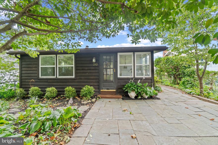 This quaint Rancher presents 2 bedrooms and 1 full bathroom in the sprawling community of Sylvan Shores. Enter the main level to a spacious sunroom filled with natural light and a family room with a gas fireplace, high vaulted ceilings, exposed beam detailing, and hardwood flooring throughout. The eat-in kitchen boasts ample counter space, black appliances, and a pass-through window to the family room for easy dining and entertaining.  The main level also features a full bathroom, a laundry room, and 2 spacious carpeted bedrooms, including the primary bedroom with two large closets. Outside, enjoy the convenience of a driveway, stone pathways to multiple entrances, lush landscaping, and a stone patio courtyard perfect for outdoor entertaining. The picturesque location near the South River offers easy access to Annapolis and the Chesapeake Bay.