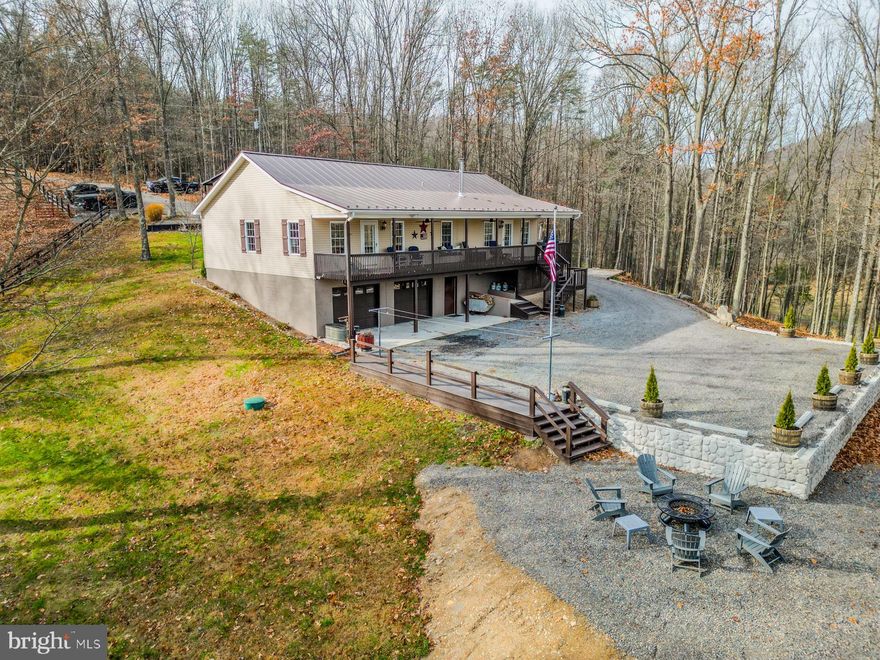 Welcome to 216 Angel Country Lane in Paw Paw, WV — a peaceful, private retreat on 47.18 acres of beautiful, usable wooded land with no HOA! This 2,030 sq. ft. raised ranch home features 3 bedrooms, 2.5 baths, and a spacious two-car basement garage with workshop space and a rear entrance. The property is fully fenced and thoughtfully designed for those who love country living, featuring a two-stall horse stable with a tack room and storage, complete with hot and cold water and electric, plus a second detached garage, storage shed, and wood shed. Outdoor living is made easy with an outdoor wood-burning boiler system (with a backup electric water heater), multiple water hydrants for convenient animal care, and even a chicken coop ready for your flock.

Over the last year, this home has been extensively updated to blend modern comfort with rustic charm. A brand-new 50-year metal roof was just installed. The rear parking area was expanded with a new retaining wall, and all decks and outbuildings have been freshly painted and sealed. A new wood shed was added, and the outdoor boiler system has been completely refurbished with a new electric water heater bypass system. Inside, you’ll find premium vinyl flooring and LED lighting throughout, two beautifully remodeled bathrooms, and all new appliances — washer, dryer, stove, refrigerator, and dishwasher — each covered by a 5-year extended warranty from Spichers Appliances in Winchester, VA. A new wood stove with a ventilation system adds cozy warmth to the living room, while new ceiling fans throughout the home, including the covered porch, provide comfort year-round. Additional improvements include two new exterior doors, a rebuilt rear staircase, and a newly created firepit area perfect for stargazing on clear West Virginia nights.

The heart of the home is the spacious country kitchen — perfectly blending old and new — featuring an electric stove and oven for everyday convenience, complemented by a wood-burning stove and oven that adds warmth, charm, and self-sufficiency.

The land itself is a dream for those seeking privacy and sustainability. There are hours of walking and riding trails to explore, including one that leads to a serene creek in the common area bordering the property. A small fenced pasture area makes this property ideal for horse owners or anyone looking to start a homestead. Personal livestock and fowl are welcome, and the abundant wildlife — including deer, turkey, and black bear — makes it perfect for those interested in hunting and living off the land. The property also features a large established garden and multiple mature peach trees, adding to its self-sufficient appeal. Fiber optic internet is already available, making it easy to work from home while enjoying high-speed connectivity in a peaceful country setting.

For outdoor enthusiasts, this area is surrounded by opportunity — just a short drive to both the Cacapon River and North River for fishing, tubing, kayaking, and relaxation. With 47+ acres, there’s even potential for Airbnb or short-term rental cabins throughout the property for those with investment or income aspirations. You're just 40 minutes to Winchester, VA for shopping, restaurants,  entertainment, and the areas largest hospital, a few minutes to the Slanesville General Store for gas and essentials, and a short drive to the historic town of Romney, offering restaurants, festivals, and sightseeing.

This area has so much to offer beyond peace and tranquility — it’s a place to live, work, and thrive. Whether your goal is to raise animals, garden, hunt, or simply enjoy a sustainable rural lifestyle, this property delivers the very best of West Virginia country living — with total freedom and no HOA.
