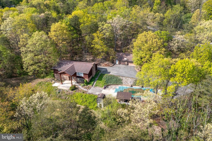 A HOME WITH ACREAGE IN THE FRANKFORT DISTRICT! Welcome to 123 Charles Street. This cedar-sided bi-level home offers 3 bedrooms, 3 bathrooms on a private 2.01 acre lot. Conveniently located, this property is minutes from Cumberland but with West Virginia taxes. The main level features an open-concept kitchen, living room and dining area with Brazilian hardwood floors. There is a primary suite with an attached laundry room/bathroom, two additional bedrooms and a large full bathroom. The basement is completely finished with a stone propane fireplace, a third additional full bathroom and a storage room. Outside, there is a 40x20 in-ground pool with an outdoor kitchen/bar, a covered patio, and a slab with electric waiting for a hot tub. There is also a two-car detached garage in addition to two wells- one feeding the house and one feeding the pool. DO NOT MISS THIS ONE! This house is occupied! Absolutely NO drive-bys! You must be with a realtor and have confirmed appointment!!!!!!