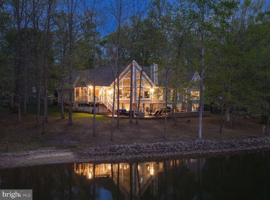 Rental Projection is in MLS Documents Section! Tucked away on the private side of Lake Anna in Noah’s Landing Subdivision, this gorgeous custom-built waterfront home offers the kind of setting that’s hard to find—quiet, private, and right on the water. Set on 1 acre with 230 feet of shoreline and deep water off the boat dock, the property features riprap along the shoreline and a natural, wooded backdrop that enhances the privacy and views. High-speed Firefly fiber internet is available, bringing fast, reliable connectivity to this peaceful lake retreat. Inside, the home is filled with thoughtful upgrades and timeless finishes. The great room showcases vaulted ceilings, expansive floor-to-ceiling windows designed to maximize the lake views, and a wood-burning stone fireplace that anchors the space. Hunter Douglas remote-controlled blinds add both comfort and convenience. The spacious kitchen is built for gathering and everyday use alike, featuring stainless steel appliances, granite counters, a walk-in pantry, center island, soft close cabinets, and a breakfast bar with seating. There is also a stylish wet bar with silestone countertops. Engineered hardwood flooring runs throughout the home, complemented by 9-foot ceilings and a spacious, open layout that creates a bright and connected feel from room to room. The layout offers 4 bedrooms, including a main-level primary suite along with a dedicated home office with french doors and 3.5 bathrooms—giving the home flexibility for full-time living or extended lake stays. The lower level offers a welcoming family room, three bedrooms, and two full baths—including one with its own private ensuite for added comfort and privacy. Two of the bedrooms are finished with plantation blinds, adding a clean, coastal-inspired feel that enhances the relaxed lake lifestyle. Outside, the backyard opens up to a massive paver patio with multiple defined areas for seating, dining, and gathering around the fire pit. It’s a natural extension of the home—an easy place to spend the day from morning coffee to evenings under the stars. There is also a dedicated propane line for the grill making grilling out a breeze. From here, a gentle path leads down to the water and boathouse featuring an electric lift, storage room, and a large sun deck that sits right over the deep water. Additional upgrades include a whole-house generator, lake-fed irrigation system, Hardi Plank and stone siding, and a Rinnai tankless water heater. TVs, washer and dryer, garage freezer and extra refrigerator in the storage room convey with the home. With its combination of setting, upgrades, and strong outdoor lifestyle features, this property is equally well suited as a primary home, a short-term rental or a private lake escape. It’s a comfortable, well-equipped Lake Anna home that delivers where it matters most—on the water! Come see for yourself!