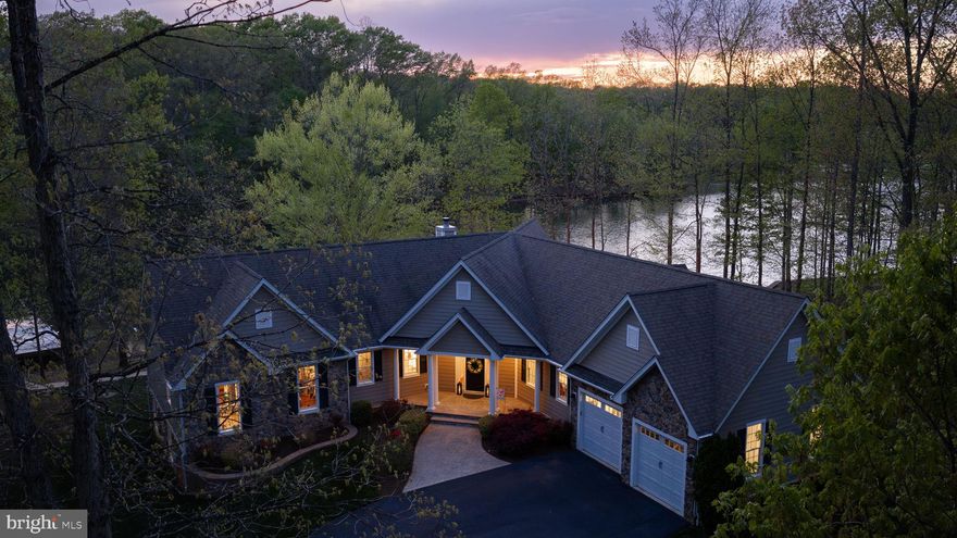 Rental Projection is in MLS Documents Section! Tucked away on the private side of Lake Anna in Noah’s Landing Subdivision, this gorgeous custom-built waterfront home offers the kind of setting that’s hard to find—quiet, private, and right on the water. Set on 1 acre with 230 feet of shoreline and deep water off the boat dock, the property features riprap along the shoreline and a natural, wooded backdrop that enhances the privacy and views. High-speed Firefly fiber internet is available, bringing fast, reliable connectivity to this peaceful lake retreat. Inside, the home is filled with thoughtful upgrades and timeless finishes. The great room showcases vaulted ceilings, expansive floor-to-ceiling windows designed to maximize the lake views, and a wood-burning stone fireplace that anchors the space. Hunter Douglas remote-controlled blinds add both comfort and convenience. The spacious kitchen is built for gathering and everyday use alike, featuring stainless steel appliances, granite counters, a walk-in pantry, center island, soft close cabinets, and a breakfast bar with seating. There is also a stylish wet bar with silestone countertops. Engineered hardwood flooring runs throughout the home, complemented by 9-foot ceilings and a spacious, open layout that creates a bright and connected feel from room to room. The layout offers 5 bedrooms and 3.5 bathrooms—giving the home flexibility for full-time living or extended lake stays. The spacious lakeside main level primary bedroom suite features beautiful views of the lake, his and her walk-in closets, a tiled walk-in shower with two niches, and separate vanities. The lower level offers a welcoming family room, three bedrooms, and two full baths—including one with its own private ensuite for added comfort and privacy. Two of the bedrooms are finished with plantation blinds, adding a clean, coastal-inspired feel that enhances the relaxed lake lifestyle. Outside, the backyard opens up to a massive paver patio with multiple defined areas for seating, dining, and gathering around the fire pit. It’s a natural extension of the home—an easy place to spend the day from morning coffee to evenings under the stars. There is also a dedicated propane line for the grill making grilling out a breeze. From here, a gentle path leads down to the water and boathouse featuring an electric lift, storage room, and a large sun deck that sits right over the deep water. Additional upgrades include a whole-house generator, lake-fed irrigation system, Hardi Plank and stone siding, and a Rinnai tankless water heater. TVs, washer and dryer, garage freezer and extra refrigerator in the storage room convey with the home. With its combination of setting, upgrades, and strong outdoor lifestyle features, this property is equally well suited as a primary home, a short-term rental or a private lake escape. It’s a comfortable, well-equipped Lake Anna home that delivers where it matters most—on the water! Come see for yourself!