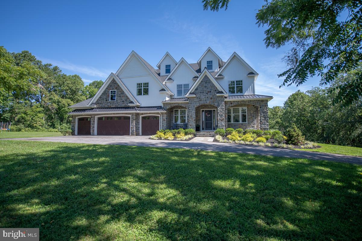 Almost New Custom Built 5 Bedroom, 6 ½ Bath, 2 Story Stone Front Colonial on a Park Like 2.2 acre Homesite Nestled Up Against 18+ Acres of Open Ground with a Conservation Easement that can Never be Developed. This Home Boasts 5,290 Sq Ft of Living Area with Over 1,300 Sq Ft ft of Additional Finished Space in the Walkout Basement and an Oversized 4 Car Garage. The Main Floor has 10? Ceilings, 7 ½? Plank Hardwood Flooring and Extensive Recessed Lighting Throughout. The Large Living Room Has a Raised Hearth Stone Fireplace with Barn Beam Mantle and Provides Spectacular Views of the Dedicated Open Space Through its Wall of 7' Windows. The Gourmet Eat In Kitchen Features an Enormous Work Island with Farmhouse Sink, Calcutta Gold Quartz Countertops with Herringbone Backsplash, White Cabinetry, Large Pantry, Atrium Door Access to Covered Deck and Luxury Appliances Including Double Wall Oven, Six Burner Gas Range with Gridle, Built In Dishwasher and Beverage Center. One of the Great Features of this Home is the Large Main Floor Bedroom with En Suite Bath, Walk in Closet and Atrium Door Access to Large Composite Deck. The Planning Center is at the Center of the House and it?s there You?ll find Built In Cubbies with Mahogany Base, First Floor Laundry Room, Powder Room, Desk Area with Quartz Countertop and the Back Staircase to the Second Floor. The Second Floor has 9? Ceilings and Extensive Recessed Lighting Throughout. The Large Master Suite Has Sweeping Views of the Open Space, Two Large Walk In Closets and is Complete with Luxurious Master Bathroom Featuring Large Tile Shower. Three Additional Bedrooms Each with an En Suite Bathroom and Large Walk in Closets are also Featured on the Second Floor. Each with its Own Unique Character. A Loft, Large Linen Closet and Full Laundry Room with Tile Floor, Built in Cabinetry and Laundry Sink are Down the Hallway. The Walkout Basement has Lots of Natural Light with Windows and an Atrium Door to the Level Backyard. The Walkout Basement is Nearly 2,600 Sq Ft. Over 1,300 Sq Ft is Finished Space and Features an Awesome Maple Bar with Pendant Lights, Subway Tile Accent Wall, Built In Cabinetry, Dishwasher and Fridge. Located Within Walking Distance of Binky Lee Preserve and within a Short Ride to Major Highways and Shopping, this is a Home you Won't Want to Miss