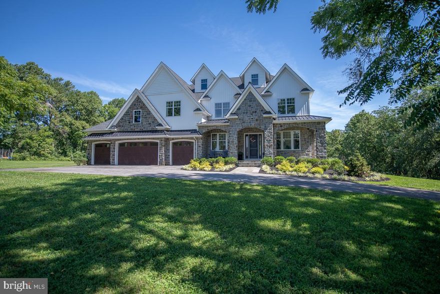 Almost New Custom Built 5 Bedroom, 6 ½ Bath, 2 Story Stone Front Colonial on a Park Like 2.2 acre Homesite Nestled Up Against 18+ Acres of Open Ground with a Conservation Easement that can Never be Developed.  This Home Boasts 5,290 Sq Ft of Living Area with Over 1,300 Sq Ft ft of Additional Finished Space in the Walkout Basement and an Oversized 4 Car Garage.   The Main Floor has 10? Ceilings, 7 ½? Plank Hardwood Flooring and Extensive Recessed Lighting Throughout.  The Large Living Room Has a Raised Hearth Stone Fireplace with Barn Beam Mantle and Provides Spectacular Views of the Dedicated Open Space Through its Wall of 7' Windows.  The Gourmet Eat In Kitchen Features an Enormous Work Island with Farmhouse Sink, Calcutta Gold Quartz Countertops with Herringbone Backsplash, White Cabinetry, Large Pantry, Atrium Door Access to Covered Deck and Luxury Appliances Including Double Wall Oven, Six Burner Gas Range with Gridle, Built In Dishwasher and Beverage Center.  One of the Great Features of this Home is the Large Main Floor Bedroom with En Suite Bath, Walk in Closet and Atrium Door Access to Large Composite Deck. The Planning Center is at the Center of the House and it?s there You?ll find Built In Cubbies with Mahogany Base, First Floor Laundry Room, Powder Room, Desk Area with Quartz Countertop and the Back Staircase to the Second Floor.  The Second Floor has 9? Ceilings and Extensive Recessed Lighting Throughout.  The Large Master Suite Has Sweeping Views of the Open Space, Two Large Walk In Closets and is Complete with Luxurious Master Bathroom Featuring Large Tile Shower.  Three Additional Bedrooms Each with an En Suite Bathroom and Large Walk in Closets are also Featured on the Second Floor.  Each with its Own Unique Character. A Loft, Large Linen Closet and Full Laundry Room with Tile Floor, Built in Cabinetry and Laundry Sink are Down the Hallway. The Walkout Basement has Lots of Natural Light with Windows and an Atrium Door to the Level Backyard.  The Walkout Basement is Nearly 2,600 Sq Ft.  Over 1,300 Sq Ft is Finished Space and Features an Awesome Maple Bar with Pendant Lights, Subway Tile Accent Wall, Built In Cabinetry, Dishwasher and Fridge. Located Within Walking Distance of Binky Lee Preserve and within a Short Ride to Major Highways and Shopping, this is a Home you Won't Want to Miss