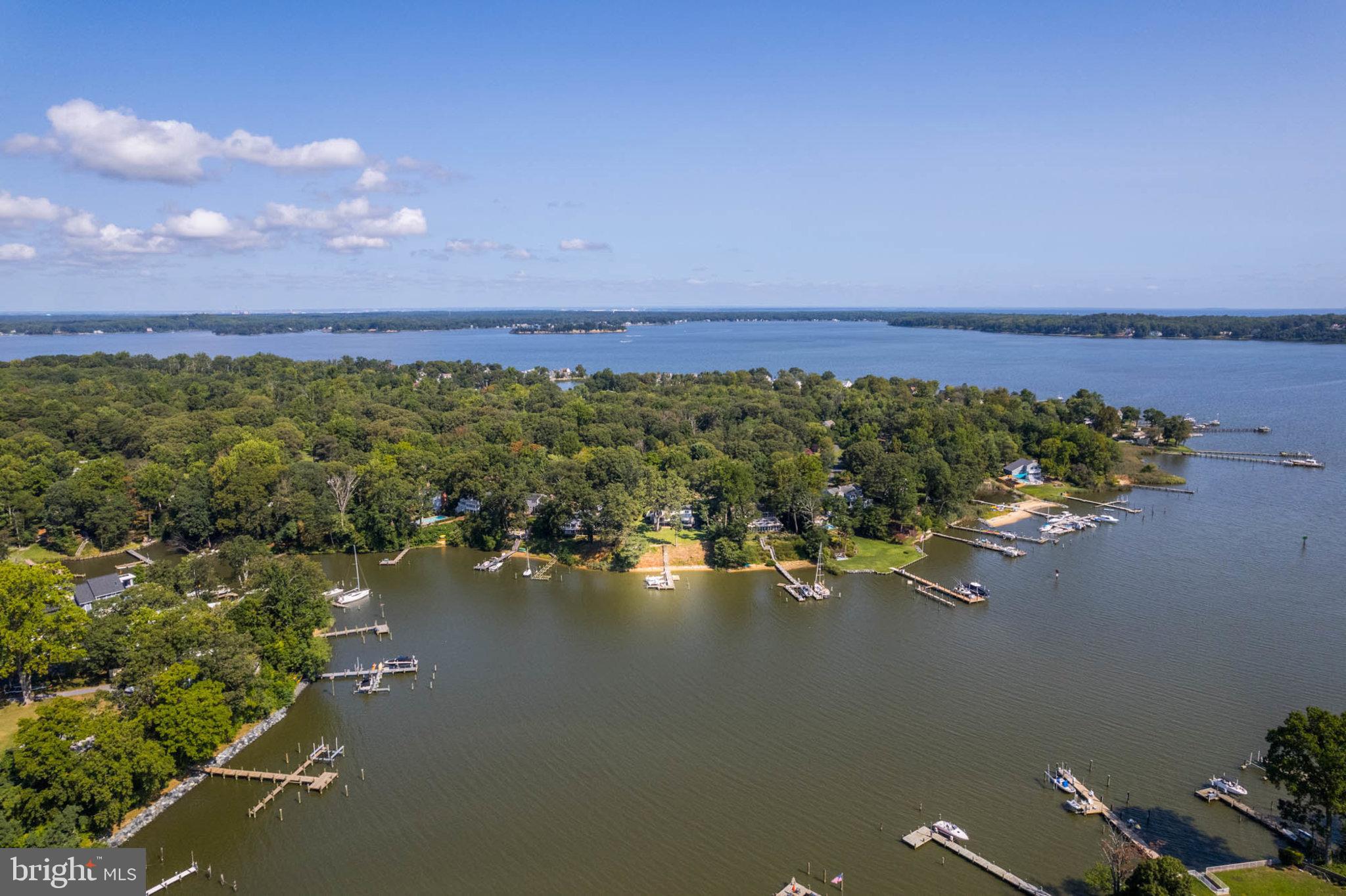 No Flood Insurance Needed---30' Above Water Level!! Imagine calling a quintessential Cape Cod home yours, nestled on a private, half-acre waterfront lot with an exclusive pier, four boat slips, and two lifts. This 5-bedroom, 2.5-bathroom gem offers a comfortable 2,667 finished sq feet of livable space, designed for quality living and entertaining. Step into a main level featuring two bedrooms, 1.5 bathrooms, a cozy living room, dining room, and a kitchen that seamlessly flows into the family room, complete with a fireplace. Let the sparkling water views seep into your living spaces through the expansive windows in the kitchen, family room, and master bedroom. Take pleasure in hosting gatherings on the spacious deck and patio, surrounded by lush greenery and mature gardens, with the deep waters of The Deep Creek just a few steps away. The upper level comprises three full bedrooms, a full bathroom, and an office that can comfortably accommodate your guests. The lower level, currently a workshop, exercise area, and storage room, offers potential for customization. The house comes with an exterior irrigation system, generator outlet, 2-zoned HVAC, and Nitron exterior lighting system, ensuring your comfort and convenience. The appliances are a mere three years old, with a five-year-old roof and a 17-year-old HVAC system. As residents of the Weatherly community, you'll gain access to a private beach, community slips, and year-round social activities. Plus, you'll be part of the Blue Ribbon public school district and have easy commuting to DC and Baltimore. Welcome to your new home at 1047 Landon Lane!