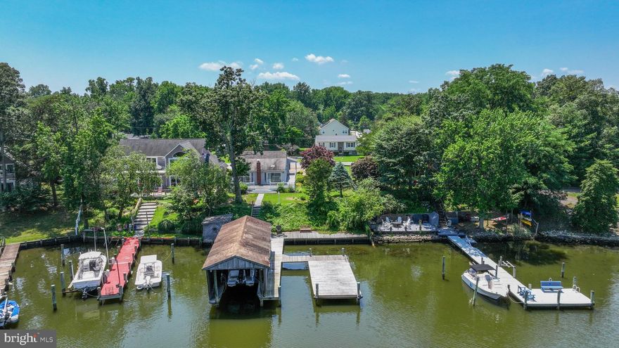 This charming Bodkin Creek waterfront bungalow is the perfect home for you and your boats! Inside, the bungalow features open, airy spaces that flow easily for everyday living, or a gathering of friends. The kitchen has a cottage feel with quality wood-tone cabinetry, silestone countertops, white appliances, center island, kitchen table space and recessed lighting. Just off the kitchen is a dining space that connects with the large, light filled living room with skylights, a wood burning stove for cool seasons, and two oversized sliders for mesmerizing views of Wharf Creek. Use the sliders to step out on the large and inviting waterfront, wrap-around deck (updated with composite and vinyl rails approx 2020), the perfect place to entertain before and after a fantastic boat day! The main level primary bedroom has a private full bath with a nice sized shower and walk-in closet. A second main level bedroom and second full bath allow for mostly one-level living. The bonus room upstairs has been enjoyed as overflow guest space. There is also a newly refinished lower level that offers flexibility for a 2nd family room, recreation room, office or guest quarters. The private pier complex, redecked in 2020, has a large boat house with a 20k lb lift (conveys as-is), 2nd slip with typical 6' water depth, decked seating area over the water, and decking that runs the 75' length of bulkheaded water frontage. Convenient shed storage is on the shoreline deck.  The boardwalk decking and slate steps were replaced about 5 years ago. Although in need of some tlc, the WF shed and boat house are items you would not be able to build new today.  An oversized 2 car garage with a large concrete driveway provides room for all of your vehicles. This lot and home are primely positioned to take advantage of one of the best boating destinations the east coast has to offer! Located within minutes of the mouth of the Bodkin and the Chesapeake Bay. In just 30-50 minutes, boat to Annapolis, Rock Hall, the Magothy River, Kent Island and Baltimore! Or stay close to home and anchor to enjoy the sunrises and sunsets in the basin of the Bodkin, where Main Creek and Back Creek converge. Walk or bike to gorgeous Downs Park via Green Gables' pedestrian access and take advantage of picnic pavilions, paved, wooded walking trails and summer concerts. With an easy commute to Baltimore, Annapolis, or DC, the prime location is perfect for full-time living or a second home. Make an appointment today and discover everything the Peninsula Life has to offer! Drone photos and video coming soon.