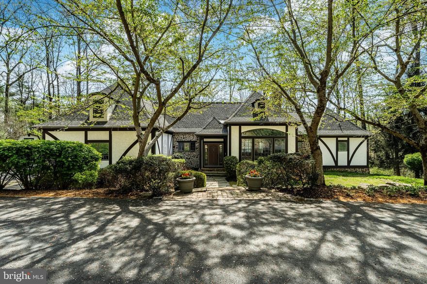 This custom Entrekin-built luxury estate is one of the most distinguished properties currently offered in Chester County. Set on 12 secluded acres and surrounded by protected open space along French Creek, this 4-bedroom, 3 full, 2 half-bath English Manor residence with Tudor-style elements blends timeless style with superior craftsmanship. Boasting over 5,000 square feet of living space, the home features handcrafted woodwork, fine millwork, and elegant architectural details throughout.
The majestic interior offers a sprawling open floor plan designed for both grand-scale entertaining and intimate living. Recent high-end updates include professionally refinished hardwood floors, new carpeting, a fresh designer paint palette, and fully updated bathrooms. The expansive Great Room (18’ x 40’) serves as the home’s heart, boasting lofted beamed ceilings and a fireplace flanked by custom built-ins. Bathed in southern light, this space flows into a chef’s kitchen featuring premium stainless appliances, including a new double oven and stovetop. Adjacent, the cozy family room offers a second floor-to-ceiling stone fireplace.
A stone archway leads to a practical wing housing a freshly painted 3-car garage, laundry with exterior access, and a guest powder room. On the opposite wing, the main-level primary suite provides a private sanctuary with a lofted ceiling, south-facing deck access, and a spa-like bath with a whirlpool tub. The upper level features two bedrooms with a Jack & Jill bath.
Practical elegance continues with significant infrastructure improvements for total peace of mind: a new roof and skylight, comprehensive HVAC replacement with a soft-start unit, a tankless hot water system, and a whole-house battery backup. Outside, the 12-acre sanctuary offers a repaved driveway, a new shed, and manicured landscaping.
The walk-out lower level—complete with a wet bar, new wood-burning stove, full guest suite, and walls of windows—is ideal for an au-pair or multi-generational living. Outside, the entertaining continues on a sprawling patio anchored by a magnificent stone fireplace.
Located in the sought-after Owen J. Roberts School District, this stately property is protected in perpetuity by a conservation easement held by the French and Pickering Creeks Conservation Trust. A home of this caliber—so rich in quality and meticulous updates—must be experienced in person to be truly appreciated.