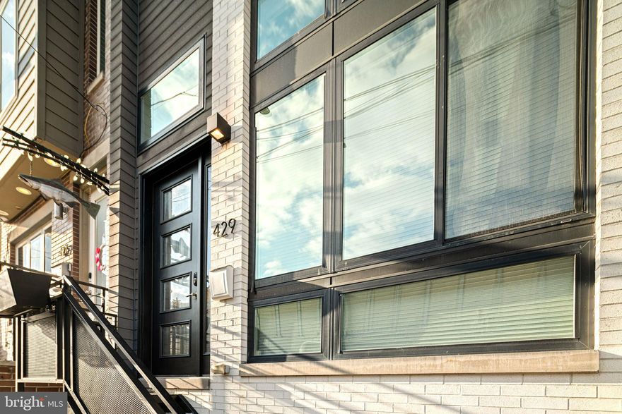Welcome to 429 Salmon Street — a bold, architectural statement in the heart of Fishtown… complete with private parking (yes, in the city 🙌).

This custom-built home was designed to impress and built to live beautifully. Think European-inspired contemporary design layered with warmth and intention. Clean lines. Glass walls. Floating staircases. Dramatic ceiling heights. And lighting throughout the home that can shift color to match your mood, your dinner party, or your late-night wind down.

The layout delivers serious flexibility:

4 spacious bedrooms

5 full bathrooms

A finished basement with 11-foot ceilings

Dedicated living room, den, dining space, and media room

Huge closets (hard to find, even in newer construction)

Laundry room

Dual HVAC systems

Smart home technology package, including built in speakers througout

And then… the rooftop deck.
Sweeping views of the Delaware River and the iconic Benjamin Franklin Bridge — the kind of backdrop that makes hosting unforgettable.

Location-wise, you’re planted in one of Philadelphia’s most dynamic neighborhoods. Grab dinner at Suraya, cocktails at Fette Sau, or brunch at La Colombe Coffee Roasters. Stroll down Frankford Ave, catch a show at Johnny Brenda's, or hop on the Market-Frankford Line for an easy commute. Major highways are also just minutes away.

This is not your standard city home.
It’s for the buyer who wants presence, privacy, parking — and a view that never gets old.