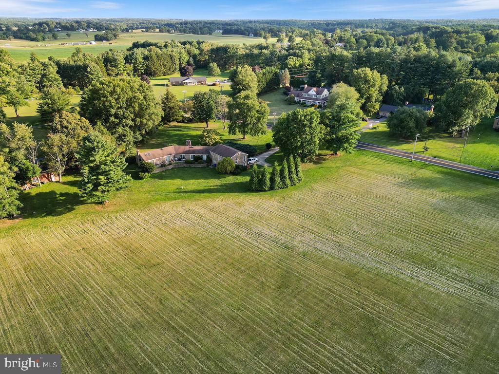 Welcome to this charming all-brick residence, boasting over 3600 sq. ft. of living space, nestled amidst the verdant expanses of Woodbine. Located on a generous 6.34-acre plot, this majestic property is the epitome of country combined with modern conveniences. Upon stepping onto the slate entryway, there is a private, covered patio where you can greet your guests or lounge and enjoy the tranquil sounds of the surrounds. Inside, the slate entry foyer features a wall of windows that lets the light shine through. Ascend a few stairs, and the beautiful slate walkway lends you to the expansive main level which offers not only all your living conveniences, but also the primary bedroom with en-suite bath, ensuring the owner has their own private haven. The remaining 3 bedrooms are located in a separate wing of the home--one of those bedrooms features an en-suite bath while the other 2 bedrooms are linked with a Jack 'n Jill bath. There are also 2 cedar lined closets in that wing! Back on the main level, the kitchen features an electric cooktop and Kitchen-Aid wall oven with microwave. The kitchen offers a center island, perfect for quick meals as well as kitchen table space for an informal dining option. Adjacent to the kitchen is the formal dining room with exposed brick wall and beamed ceilings! On the other side of the kitchen is an expansive gathering room complete with a fireplace, custom built-ins, cathedral ceilings and skylights! Some additional features of this home include another cozy fireplace in the formal living room to set the mood for those upcoming cool evenings, as well as an outdoor firepit, perfect roasting smores while delighting in the 6+ acres that make up this estate. There is also a spacious 2-car garage to ensure your vehicles remain sheltered from the elements. The property also boasts a barn, perfect for those looking for additional storage or a separate creative space. The level lot ensures maximum usability while maintaining the utmost privacy, making it a peaceful retreat away from the hustle and bustle. The vast acreage may be subdividable into one additional lot, subject to a feasibility study, presenting a unique opportunity for future endeavors or investment.
This is not just a house, but a lifestyle choice. Whether you're a nature enthusiast, have a desire for ample space, or someone seeking solitude in the midst of Maryland's beauty, this home in Woodbine promises the opportunity to be your personal sanctuary.
