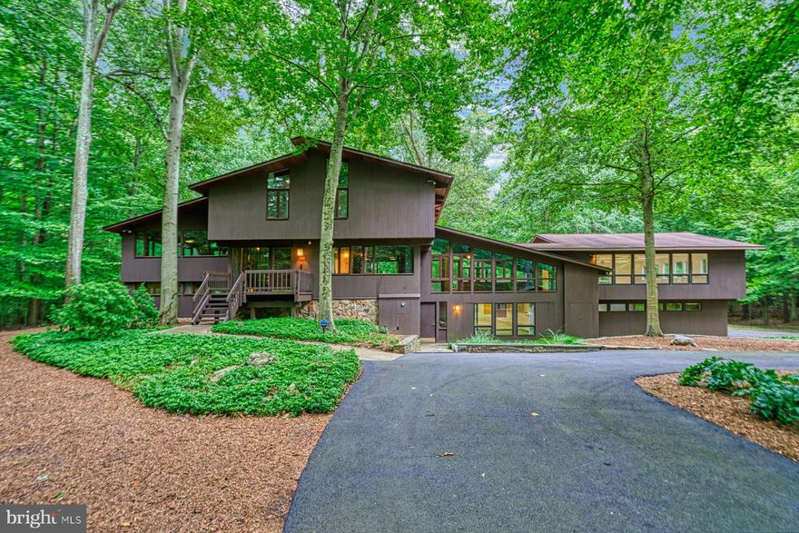 Welcome to this delightful Deckhouse, which has recently undergone some cosmetic updating to the inside, including paint, new carpeting, revarnishing of the hardwood floors and modernising of the kitchen to create a more open atmosphere. This is a true architectural gem, nestled in the highly coveted community of Carrwood Estates in Great Falls, Virginia. 

The property, built in 1980, offers an impressive estimated 6,800 square feet of living space, featuring four bedrooms plus lower level ‘flex’ room, copious space for entertaining, enormous home based hobby/business rooms and a three-car attached garage, plus a separate oversized detached garage, all situated on a generous private, wooded five-acre lot. 

Approaching this remarkable residence, one is greeted by a manicured landscape, showcasing the care this family home has received over the years. The elegant exterior design of this Deckhouse is a testament to its unique and timeless appeal, blending seamlessly with its natural surroundings. 

Step inside and prepare to be captivated by the grandeur that awaits. The expansive open floor plan of this Deckhouse provides an abundance of natural light to flood every corner, creating a warm and welcoming ambiance throughout. 

The soaring ceilings, coupled with impressive floor-to-ceiling windows, offer breathtaking views of the surrounding greenery, making one feel connected to nature at every turn. 

The main level of the residence boasts a spacious living room, complete with a cozy stone fireplace, perfect for gathering with loved ones and creating lasting memories. The adjacent dining area is nicely integrated into the living space, providing ample room for entertaining guests on both intimate and grand scales. 

The gourmet kitchen features an expansive center island (with Jennair® cooktop with fryer and BBQ inserts), and overlooks the backyard. Whether hosting a dinner party or preparing a casual meal for the family, this kitchen will cater to every need. 

The breakfast area, conveniently located just off the kitchen, with newly created pass through, offers a serene space to enjoy your morning coffee while taking in the breathtaking views of the surrounding landscape. 

The upper level of the house is home to the primary bedroom suite, offering sanctuary for relaxation and rejuvenation. A further three bedrooms are also on this level, providing comfortable accommodations for family members or guests. 

The lower level of the residence offers a plethora of possibilities. Currently being used as a recreation area, this space can easily be transformed into a home gym, a media room, or even a home office, allowing you to tailor it to your specific needs and desires. The possibilities are endless. The lower level also includes a flex/bonus room. 

The outdoor living space is equally as impressive as its interior. Step outside onto the expansive deck, where you can relax and unwind while enjoying the serene views of the surrounding nature. The vast five-acre lot provides plenty of room for outdoor activities, whether it be hosting a summer barbecue or creating your very own tranquil oasis. 

Located in the highly sought-after Carrwood Estates, close to the Potomac River, this property offers the best of both worlds – a serene and secluded retreat, while still being within close proximity to all the amenities Great Falls and beyond has to offer. Enjoy easy access to top-rated schools, upscale shopping, fine dining, and recreational activities, ensuring a lifestyle of convenience and luxury. Don't miss this rare opportunity to acquire an exceptional Deckhouse, ready for sympathetic updating, in a highly desirable location. Schedule your private showing today and experience firsthand the unparalleled beauty and elegance that this property has to offer.