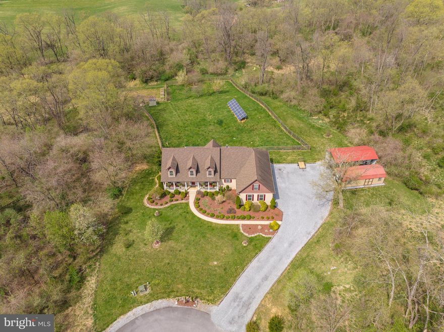 ** BIG price adjustment!  Priced below recent appraisal value.  Sellers are motivated and will consider offers!  This little slice of heaven is perfect for the growing family, multigenerational families, nature lovers, gardeners, agriculturalists, and small size farmers - horses, goats and chickens are allowed.  Nicely located at the end of a quiet cul-de-sac on a secluded 5.27 acres, this 4 bedroom,  4 bath custom-built home is meticulously maintained and packed full of upgrades.  No detail was overlooked in this beautiful home:  2 x 6 construction, composite and shake siding, 50-year shingle roofing, hardwood flooring, 10-foot ceilings, custom woodwork, and state-of-the-art appliances, high speed internet, solar energy, and new HVAC system just installed.  From the moment you enter the driveway, you will notice the mature landscaping and covered front porch which has ample space to kick back and take in the country air, natural surroundings, and sunrises.  Entering the front door, you will notice the slate tile flooring and custom built-ins that flow into the spacious family room featuring a 10 ft. ceiling, hardwood flooring, slate hearth, and a gas fireplace.  There is ample space in both of the main level bedrooms that share a nicely decorated hall bathroom which has a shower and jetted tub.  Adjoining the family room is a nicely designed, gourmet kitchen with granite countertops,  custom cabinetry, stainless appliances, a gas range, a wine bar, a dining room with custom booth seating, and a breakfast nook that accesses the rear deck and views the fenced backyard.  Continuing through the main level is the well-positioned pantry and laundry room that includes a newer washer and dryer and a convenient wash sink.  Last but not least on the main level is the primary bedroom suite.  Wow, this room sure is sweet!  Large bedroom with hardwood flooring and access to the rear deck, dual walk-in closets, dual bathrooms (one with a clawfoot tub and one with a tiled, walk-in shower), plus there is a private sitting room/office - all within the primary suite.  Upstairs, there is a semi-private bedroom and full bath with its own split-air system which is positioned just down the hall from an unbelievable, upper-level recreation room that lends itself to a plethora of family fun and entertainment:  bar, pool table, arcade games, theater room, and a storage room with built-in shelving (could be an additional bedroom if desired).  On the lower level, there is a full, unfinished basement with walkout doors plus even more options  Tons of potential down here!  This area contains a full bath rough-in,  kitchen rough-in,  a wood-burning furnace, an egress window, an outside woodshed, and a patio area.  This lower level lends itself to a possible in-law suite if desired.  Outside of the house is a fenced backyard area perfect for securing pets and children as well as protecting and maintaining your own home garden, small fruit orchard, chicken coops, and solar panels to assist with home energy purposes.  Surrounding the fenced-in portion (new fencing only a year old)  of the rear yard is a small trail with tranquil wooded areas, bee hives, and natural wildlife inhabitants.  For yard and shop working, storage,  and transportation conveniences, there is a single garage with a covered carport, a storage shed with a roll-up door, and an attached two-car garage with ample storage space and a small workshop area.  This home also contains its own water filtration system and a property-owned propane tank.  This exceptionally unique, original-owner home is ready to be yours in wild, wonderful West Virginia and historic Shepherdstown! Conveniently located minutes from the local shopping center and downtown shops, restaurants, Shepherd University, Bavarian Inn Resort, Cress Creek Country Club, C&O Canal Towpath, and a short commute to nearby Martinsburg, Charles Town, and the MARC commuter train.  Book your showing today!