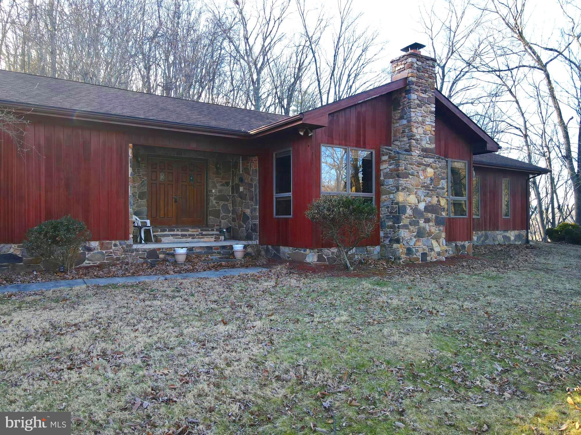 Come see this one level ranch style custom built redwood and stone home on 2.5 unrestricted rolling and wooded acres. This home is located near town, close to stores, doctors offices and hospital but secluded with wildlife as your neighbors. The home has three bedrooms, sunken living room, 2 bathrooms, kitchen, dining room, stone fireplace, 2 car garage and deck. Storage/workshop in the back yard .
