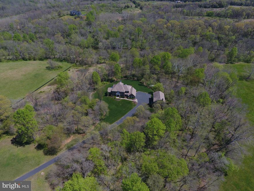 ONE OF THE PREMIER LOTS IN LOUDOUN COUNTY - CUSTOM BUILT ESTATE WITH OVER 7240 SQUARE FEET ON A 14 ACRE CONSERVANCY LOT W/400 FEET OF GOOSE CREEK FRONTAGE- SEPARATE 1075 SQUARE FOOT GUEST HOUSE WITH FULL KITCHEN, LIVING AREA, BEDROOM, OFFICE AND 1.5 BATHS - OVERSIZED 3 CAR GARAGE ON MAIN HOUSE - INDOOR SPORTS COURT/BASKETBALL COURT/GARAGE ATTACHED TO GUEST HOUSE - TOTAL OF 6 CAR GARAGE- LARGE GOURMET KITCHEN WITH  VIKING APPLIANCES & HUGE ISLAND-FORMAL LIVING AND DINING ROOMS - MAIN LEVEL ALSO HAS AN OFFICE, LARGE SUNROOM AND FAMILY ROOM - HUGE MAIN BEDROOM WITH SITTING ROOM, CUSTOM BATH AND WALK-IN CLOSET - FULLY FINISHED BASEMENT WITH THEATER RM W/SOUND SYSTEM, EXERCISE ROOM, BEDROOM & FULL BATH-1150 SQUARE FOOT DECK WITH SCREENED PORCH-GATED STONE PILLAR ENTRY & 4 BOARD FENCING-HUNT & FISH IN YOUR OWN BACKYARD-