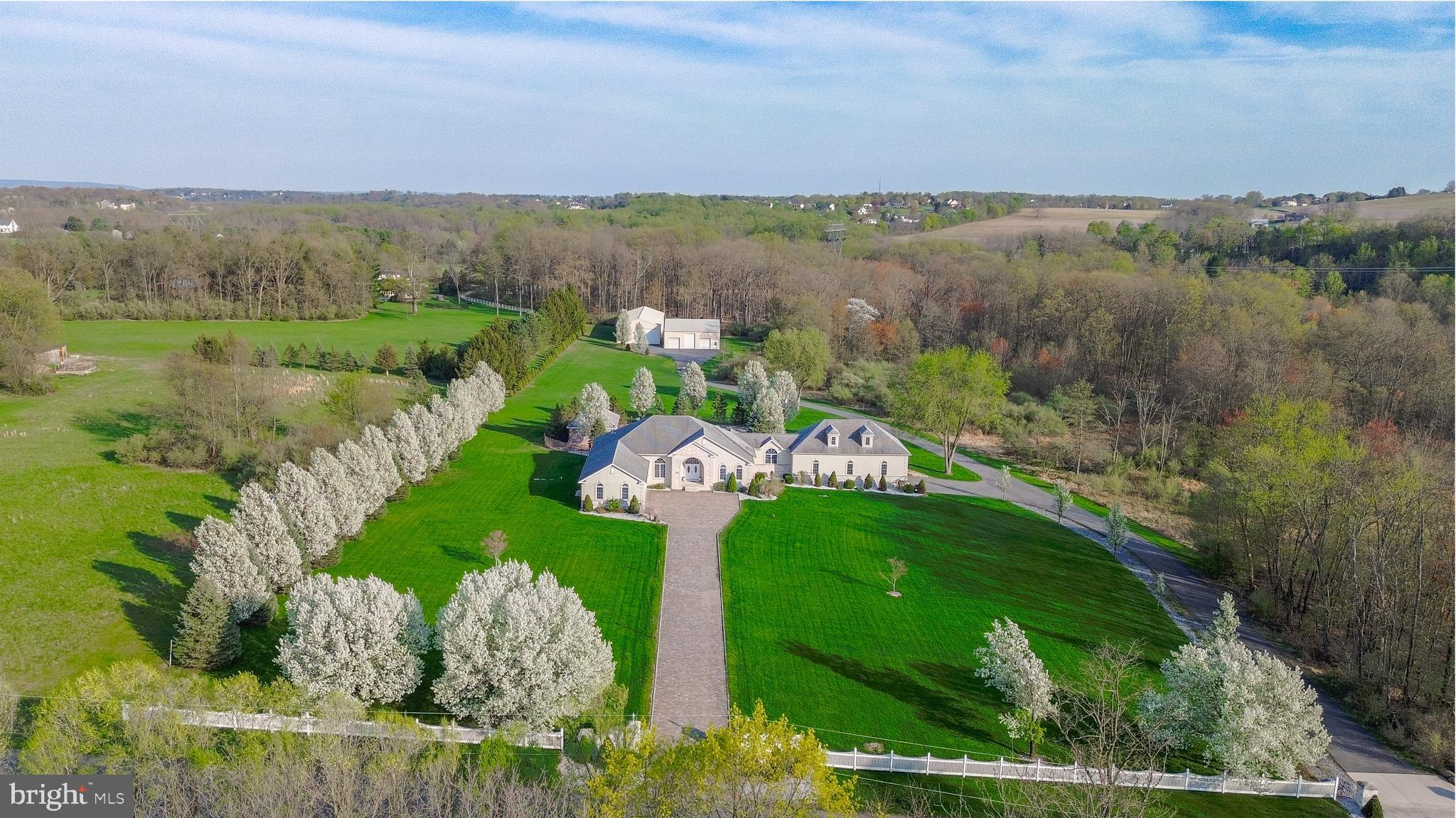This spectacular, completely renovated custom-built ranch in the coveted Fox Ridge Farms has been upgraded with the finest luxurious finishes throughout. The expansive first level boasts gleaming hardwood floors in the living room, an open-concept kitchen featuring top-of-the-line appliances, exquisite countertops, and a spacious dining room. The oversized dining room offers plenty of space for entertaining. The master suite is a true retreat, with a stunning en-suite bath & multiple walk-in closets for ample storage. This floor also includes three additional spacious bedrooms & three and a half beautifully appointed bathrooms. The fully finished basement is a perfect extension of the living space, featuring a
large family room and 3-4 additional rooms that offer endless possibilities for additional bedrooms, a gym, movie room, wine cellar, or whatever your heart desires. The attached 3-car garage and a remarkable 6-car built-in garage with two lifts is an absolute dream for car enthusiasts. Additionally, 2 large pole buildings provide versatile options for storage, workshops, or any other needs. Step outside to discover a true outdoor oasis, ideal for entertaining. Relax by the in-ground pool with a stunning waterfall, gather
around the fire pit, or enjoy the pool house complete with a built-in grill. All of this sits on 12.75 acres of private land, which is part of a covenant w/ the Wildlands Conservancy & Act 319, ensuring tranquility and privacy.