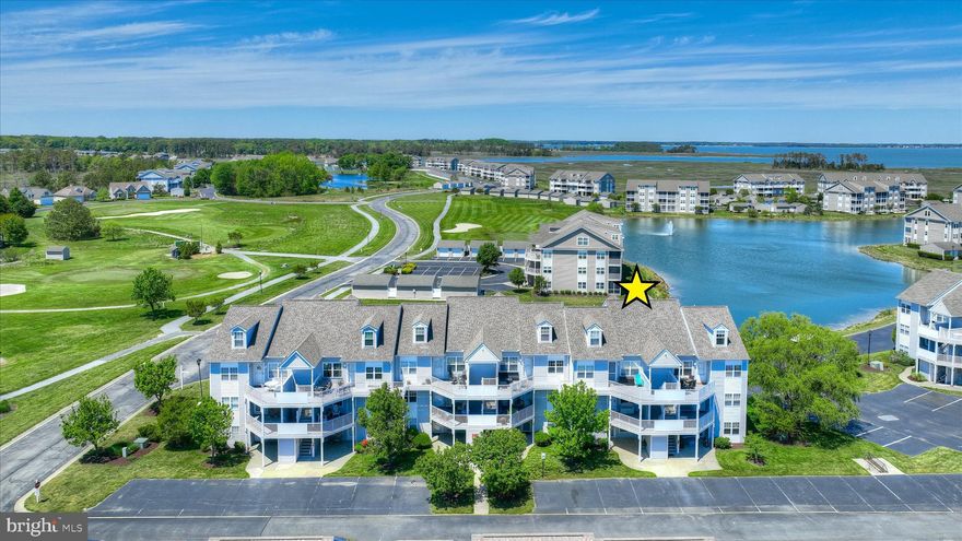 This second-floor residence in the bayfront community of Bethany Bay offers a wonderful blend of comfort, coastal charm, and proximity to amenities. Ideally positioned near the water, the building enjoys a peaceful setting close to the bay, with glimpses of the water visible from both the private balcony and rear bedroom.

Inside, the bright and welcoming kitchen features a breakfast nook and a convenient pass-through to the dining area, creating an easy flow for everyday living and entertaining. The dining space opens seamlessly to the living room, where sliding glass doors lead to a screened balcony, an inviting retreat to enjoy coastal breezes and tranquil surroundings in comfort.

The primary suite is thoughtfully situated off the living area and includes an en suite bath along with subtle water views, offering a relaxing private escape. A second bedroom at the front of the unit and a full hall bath provide comfortable accommodations for guests or family. A washer and dryer are conveniently located within the unit for added ease.
Located just minutes from Bethany Beach, this home offers access to an array of community amenities, including a golf course, swimming pool, pickleball and tennis courts, kayak storage, playground, boat ramp, and clubhouse. Snow and trash removal are also included, making for a low-maintenance coastal lifestyle in a scenic, amenity-rich setting.
