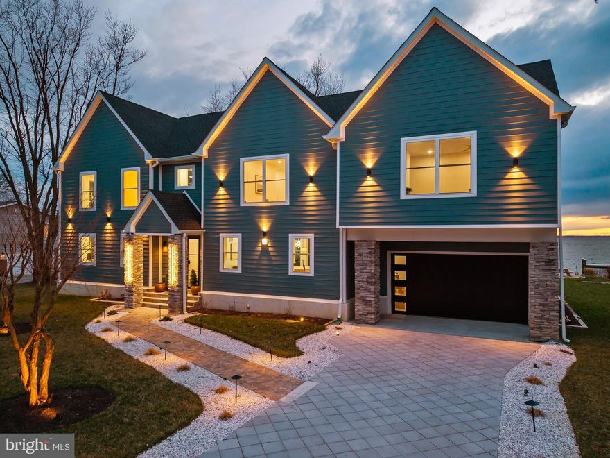 Designed by YSA Homes and Simply Wesley Interior Design of Annapolis, this extraordinary brand-new modern coastal farmhouse style smart-home offers over 6,148 square feet of thoughtfully designed living space, where every tile throughout the home was handpicked and expertly curated using top-of-the-line luxury selections. The kitchen is outfitted with premium, top-tier appliances including Wolf, creating a seamless blend of elevated craftsmanship, timeless design, and modern functionality at every turn. The property is permitted for a pool to be built.

This stunning residence features five oversized bedrooms, each with its own expansive en suite bathroom, and three of the five have waterfront bay views. Totals include six full bathrooms, two half bathrooms, five gigantic bedrooms, 2 car oversized attached garage with rear entry door. An owner’s suite on the main level (with huge custom closet) provides everyday convenience, while the second level includes an additional  owner’s suite with a massive custom walk-in closet, ideal for multi-generational living or extended guest stays.

Upon entering the home, you are welcomed into an open-concept main level where the kitchen flows seamlessly into the dining and living areas, creating an ideal setting for entertaining and everyday living. The living room is anchored by a striking wireless water vapor fireplace, offering modern ambiance without heat or emissions. A main-level half bath adds convenience, while the primary suite features a spa-inspired oversized bathroom with a soaking tub, a large European-style walk-in shower, and exquisite designer finishes throughout.

The second level impresses with a spacious great room, complete with a wet bar and an additional half bath, opening to a large upper-level deck designed for optimal water views and entertaining. Four generously sized en suite bedrooms are located on this level, two of which showcase stunning water views through oversized windows, filling the space with natural light.

The lower level offers exceptional flexibility, featuring a walk-out basement with exterior sliding doors, a full bathroom, a dedicated laundry room, and ample space for a game room, den, home gym, or additional living areas. Ask the listing agent about available improvement and build-out options for the basement. Outdoor living continues on the main-level patio, with the option to expand or customize to suit your vision.

Located on sought-after Kent Island, this home offers access to a true Chesapeake Bay lifestyle just approximately 20 minutes from historic downtown Annapolis. Enjoy nearby waterfront parks, marinas, beaches, and miles of scenic walking and biking trails along the Cross Island Trail. Golf enthusiasts will appreciate proximity to Blue Heron Golf Course with membership options available, as well as the nationally recognized Queenstown Harbor Golf Links featuring two championship courses. Residents can easily enjoy all that downtown Annapolis has to offer, including boutique shopping, waterfront dining, sailing culture, festivals, and the charm of the historic district and U.S. Naval Academy. Just minutes away, **Queenstown Premium Outlets—featuring Calvin Klein, J.Crew, and other popular brand-name retailers—*provide convenient access to everyday shopping. Kent Island is also home to waterfront dining, local crab houses, and Love Point Vineyards, while Terrapin Nature Park and Matapeake Beach offer stunning Chesapeake Bay views. Conveniently positioned for commuting to Baltimore and Washington, D.C., this location blends coastal living with everyday accessibility. This is not just a home, this is a coastal lifestyle.